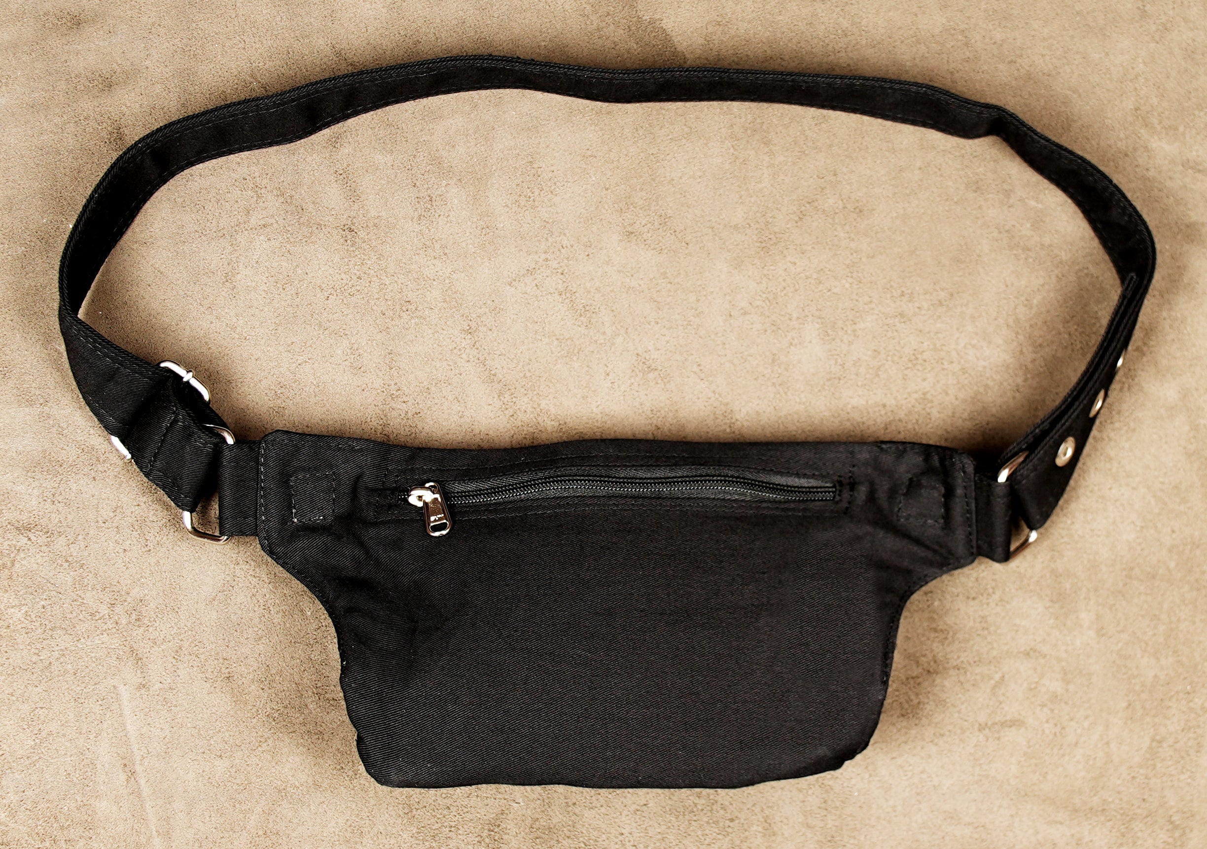 Hands-free black canvas belt bag with a secure front flap for festival-goers.