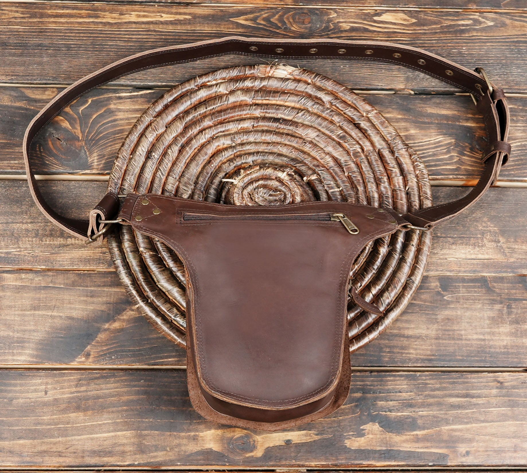 Brown leather waist bag with black front panel and rivet accents