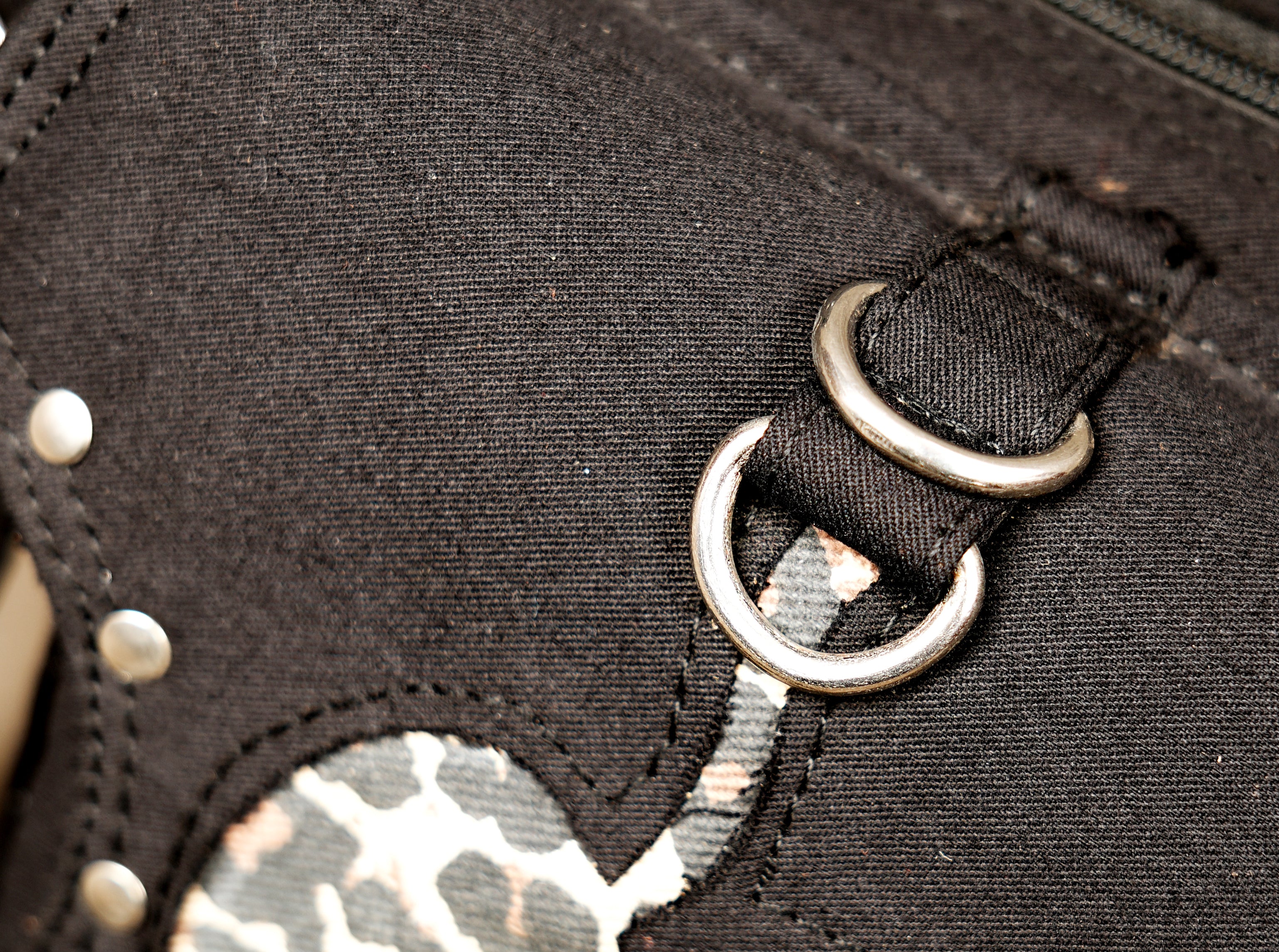 View of the sturdy silver-tone metal buckles and rings used on the adjustable belt straps.