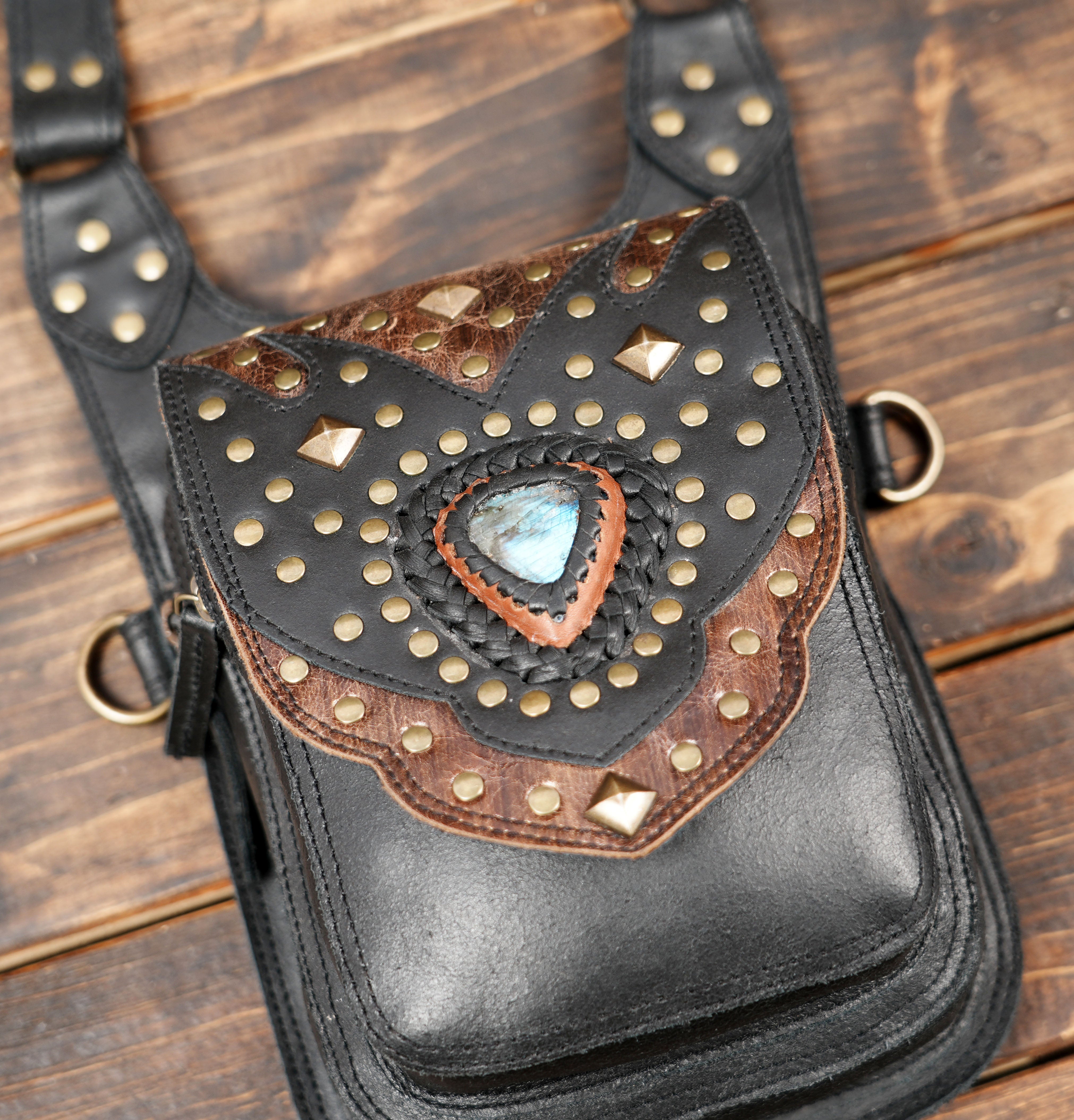 “Steampunk-inspired leather shoulder holster with decorative metal studs and gemstone inlay”