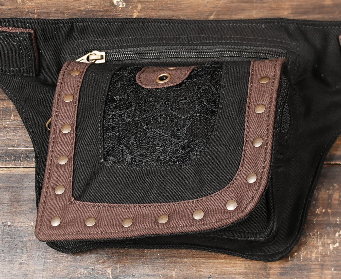 Close-up of canvas hip pouch with lace detail and brass accents