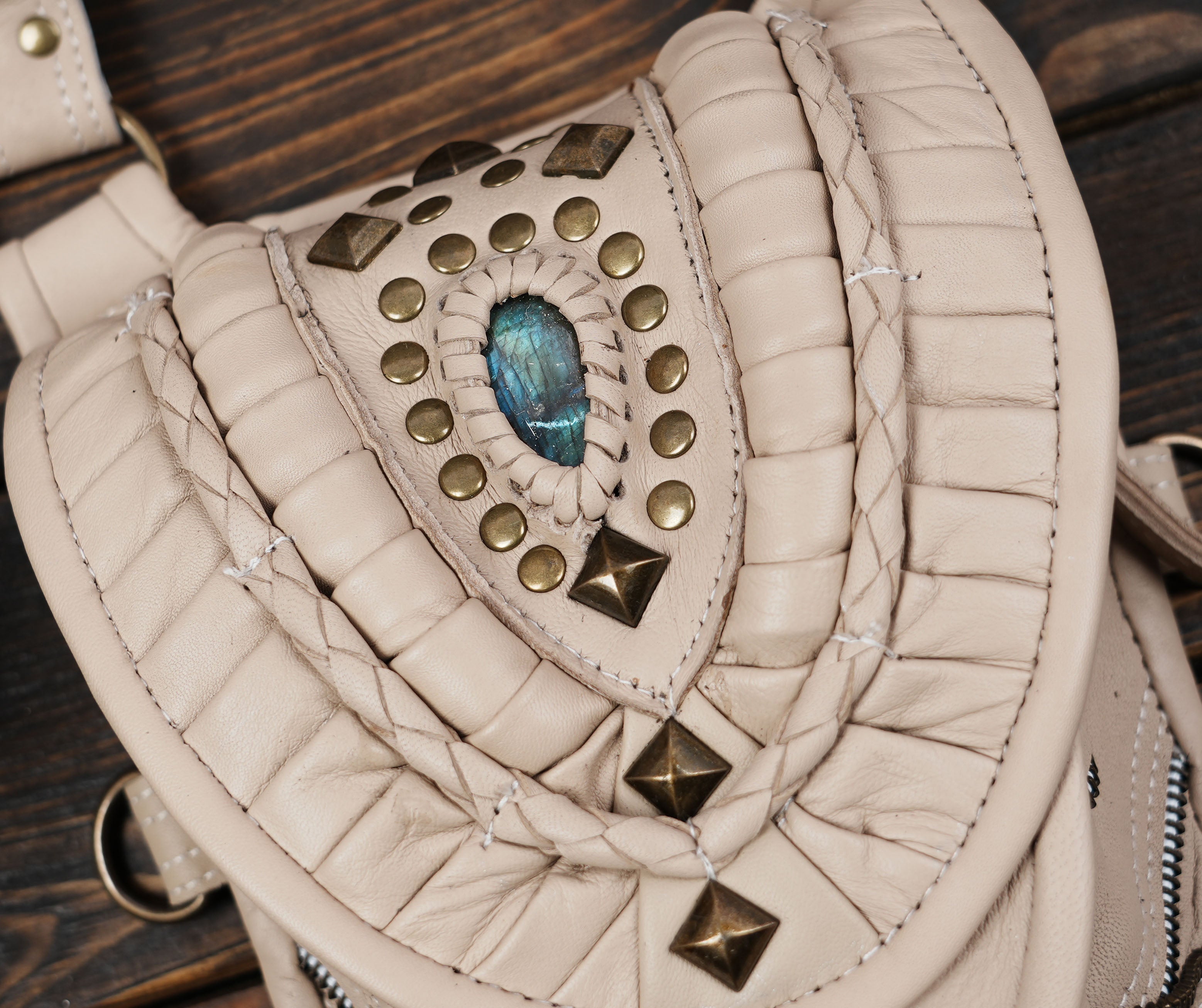 “Hand-stitched cream leather holster with gemstone centerpiece and brass rivets”