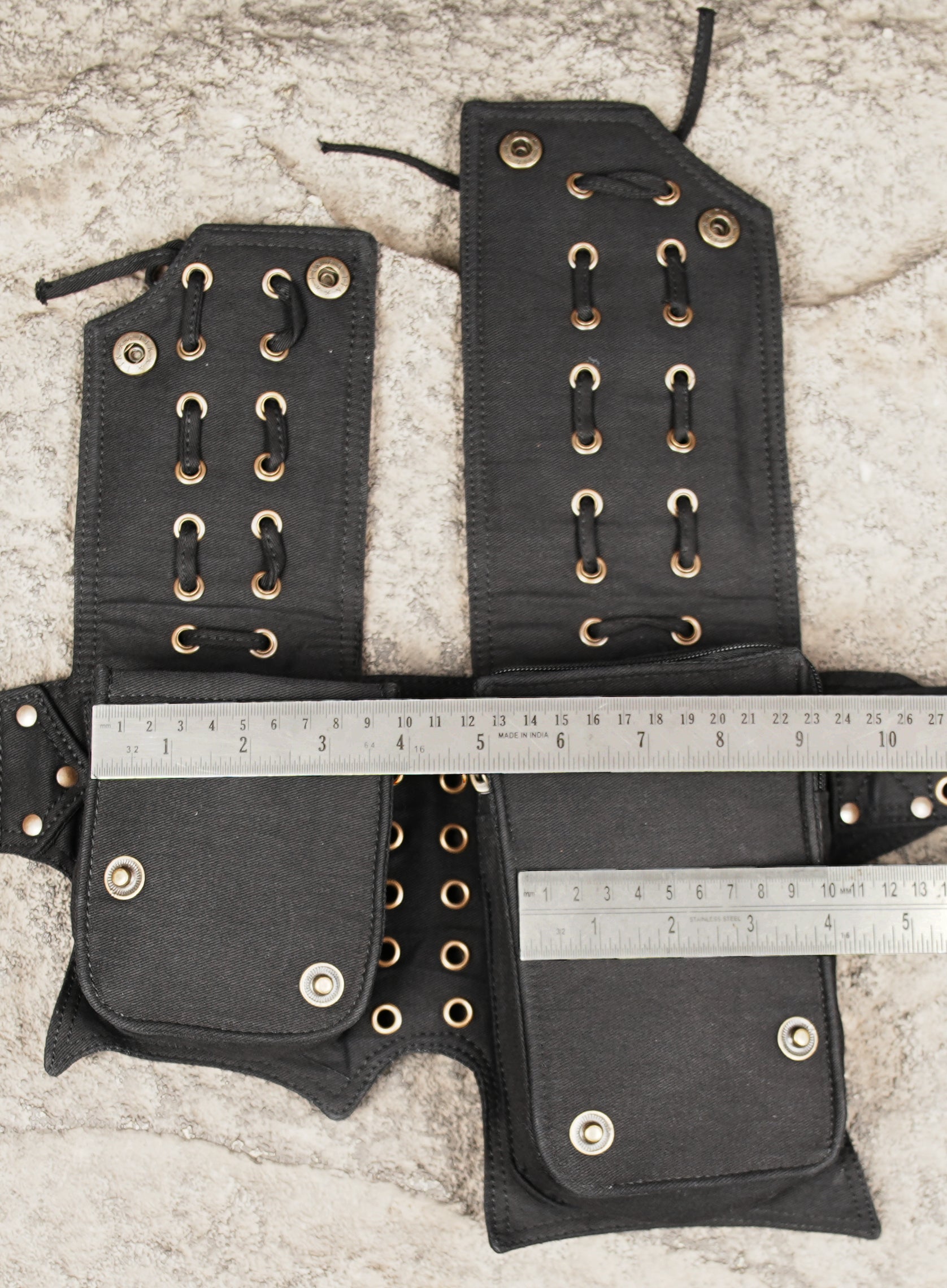 Outdoor travel hip pack made from durable black fabric with grommets
