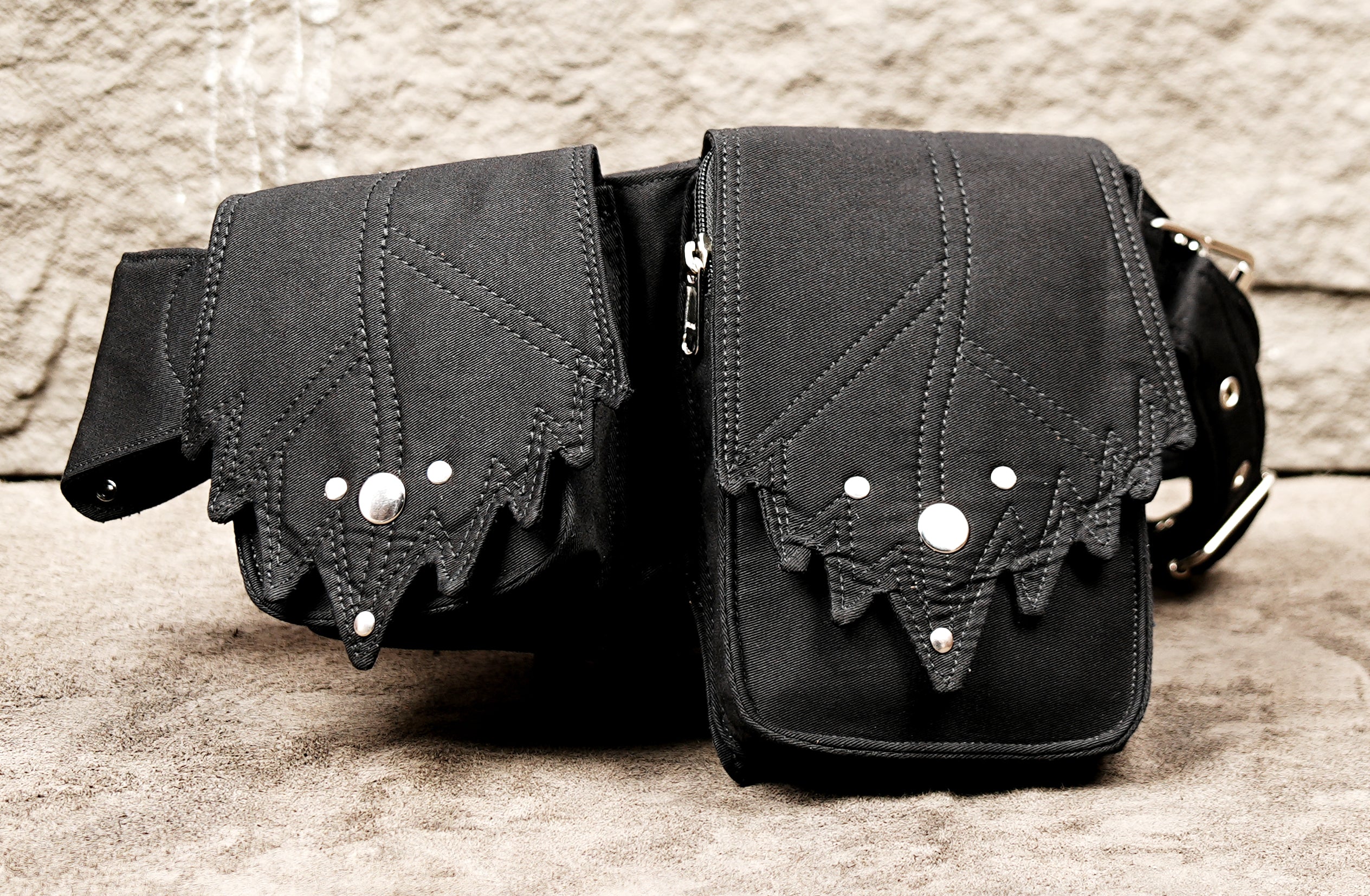 Gothic-style black canvas multi-pouch belt with metal rivets and pyramid studs.