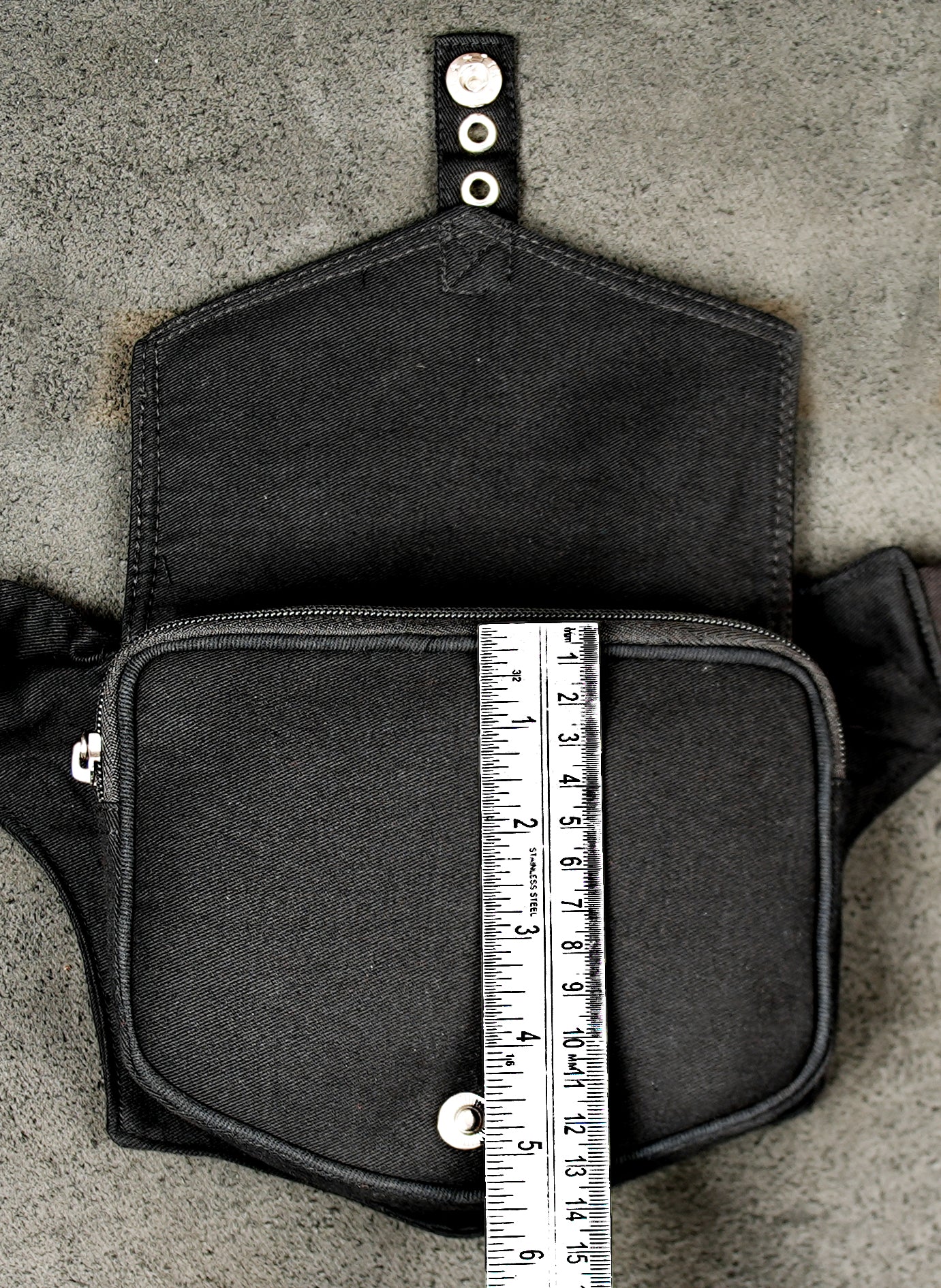 Modern black belt bag with a single pocket and classic metal buckle closure.
