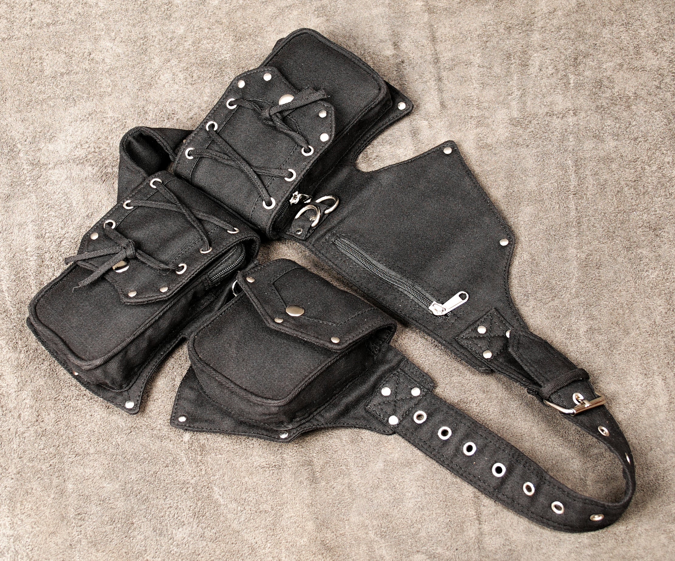 Unisex black cotton waist bag with an edgy, utilitarian design, shown flat.