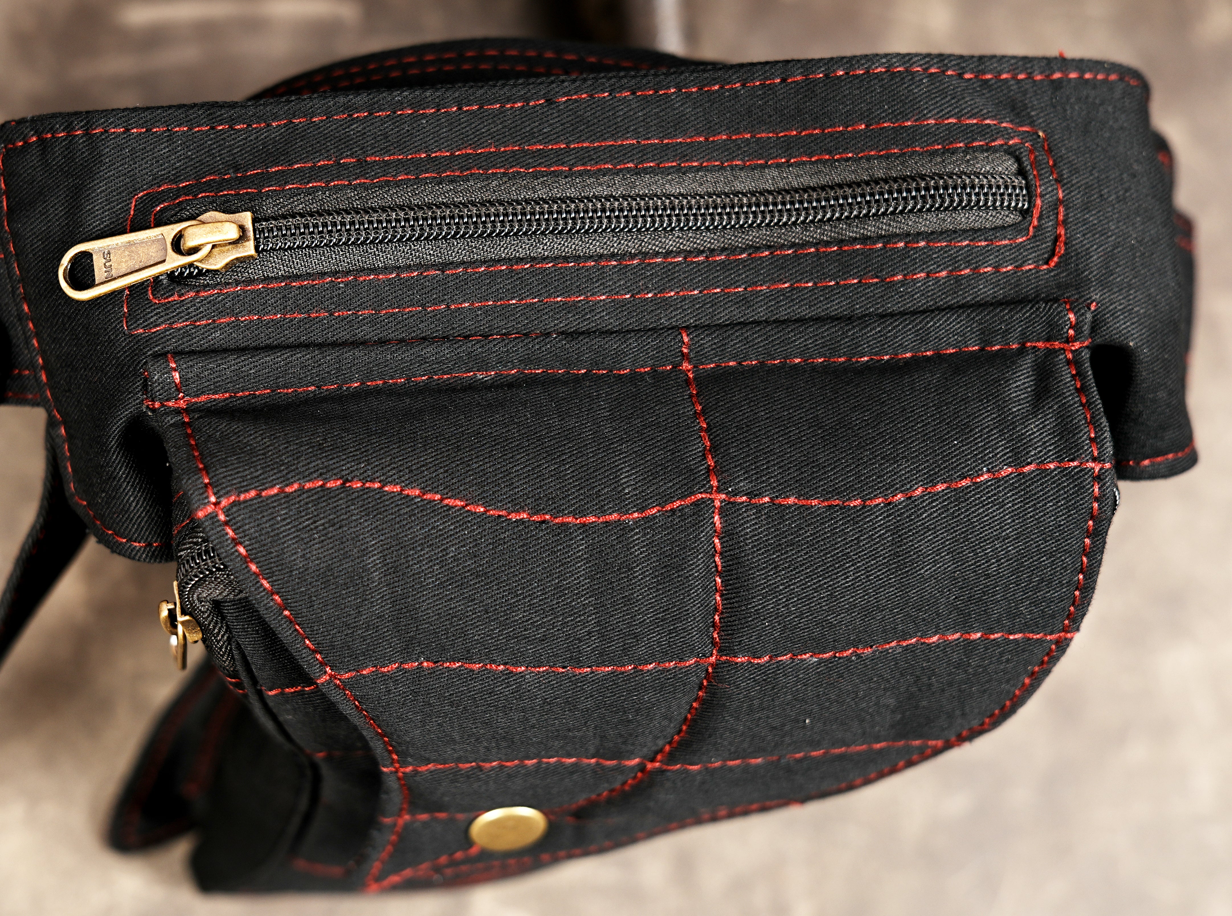 Cotton canvas bum bag with red stitch accents on mottled gray background
