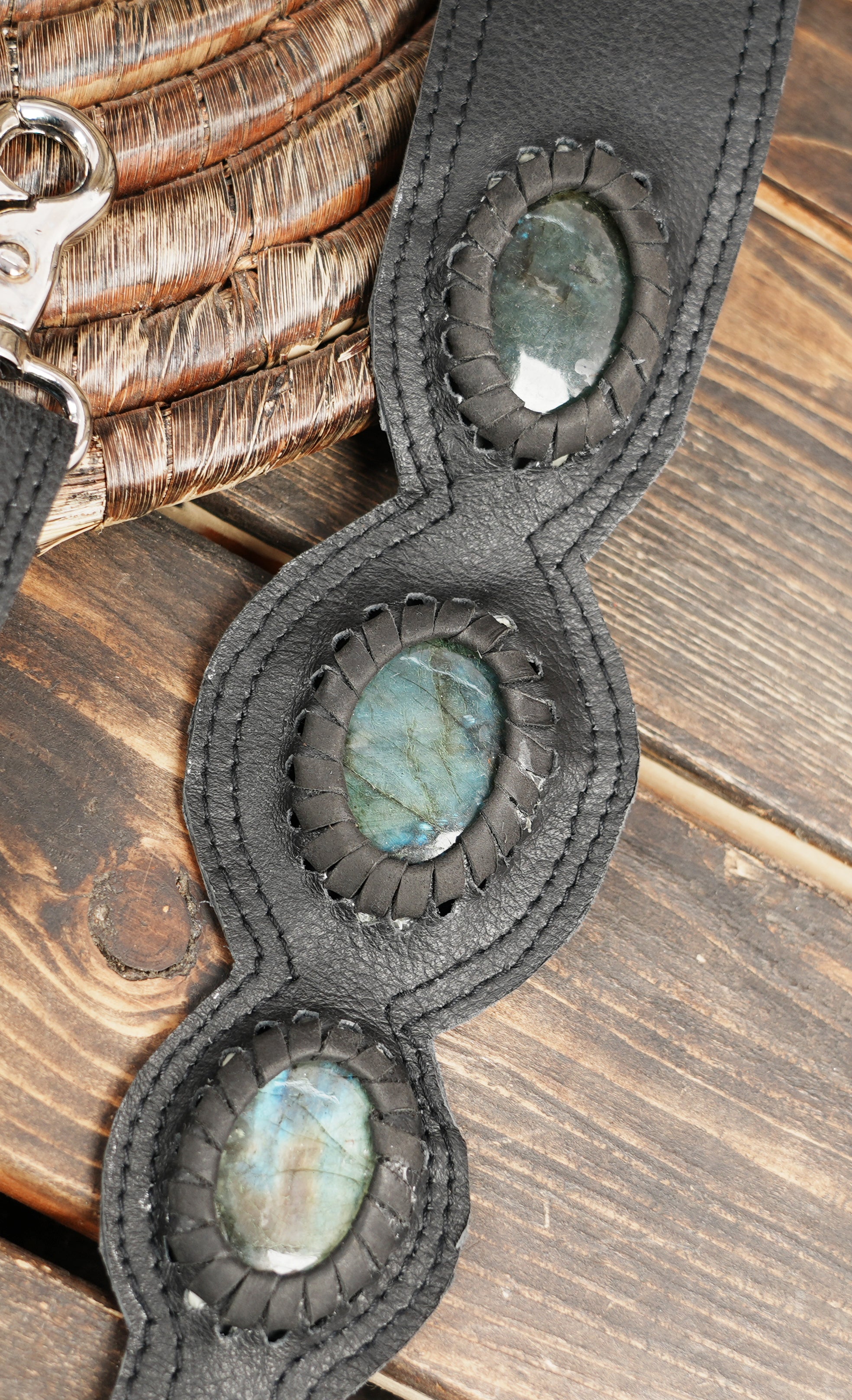 Black leather harness bag with adjustable straps and decorative gemstone panels