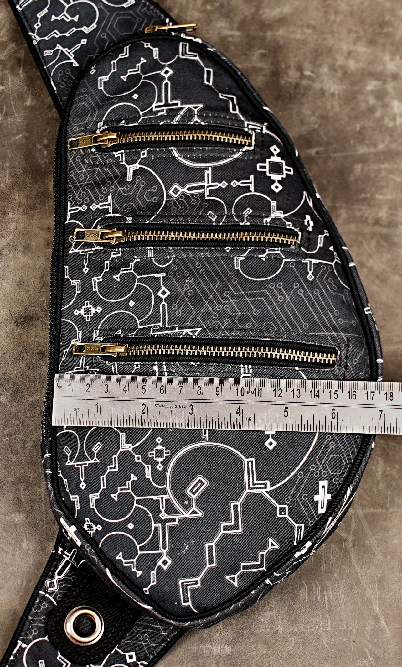 Close view of zipper pockets on cyberpunk print shoulder bag