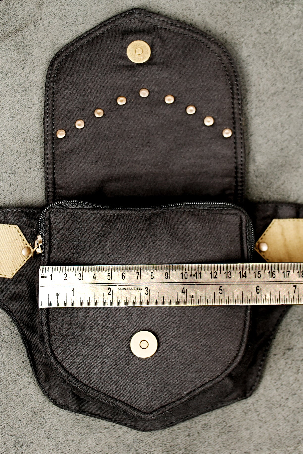 A closer look at the unique chevron-shaped hardware piece and the stud work on this hip bag.