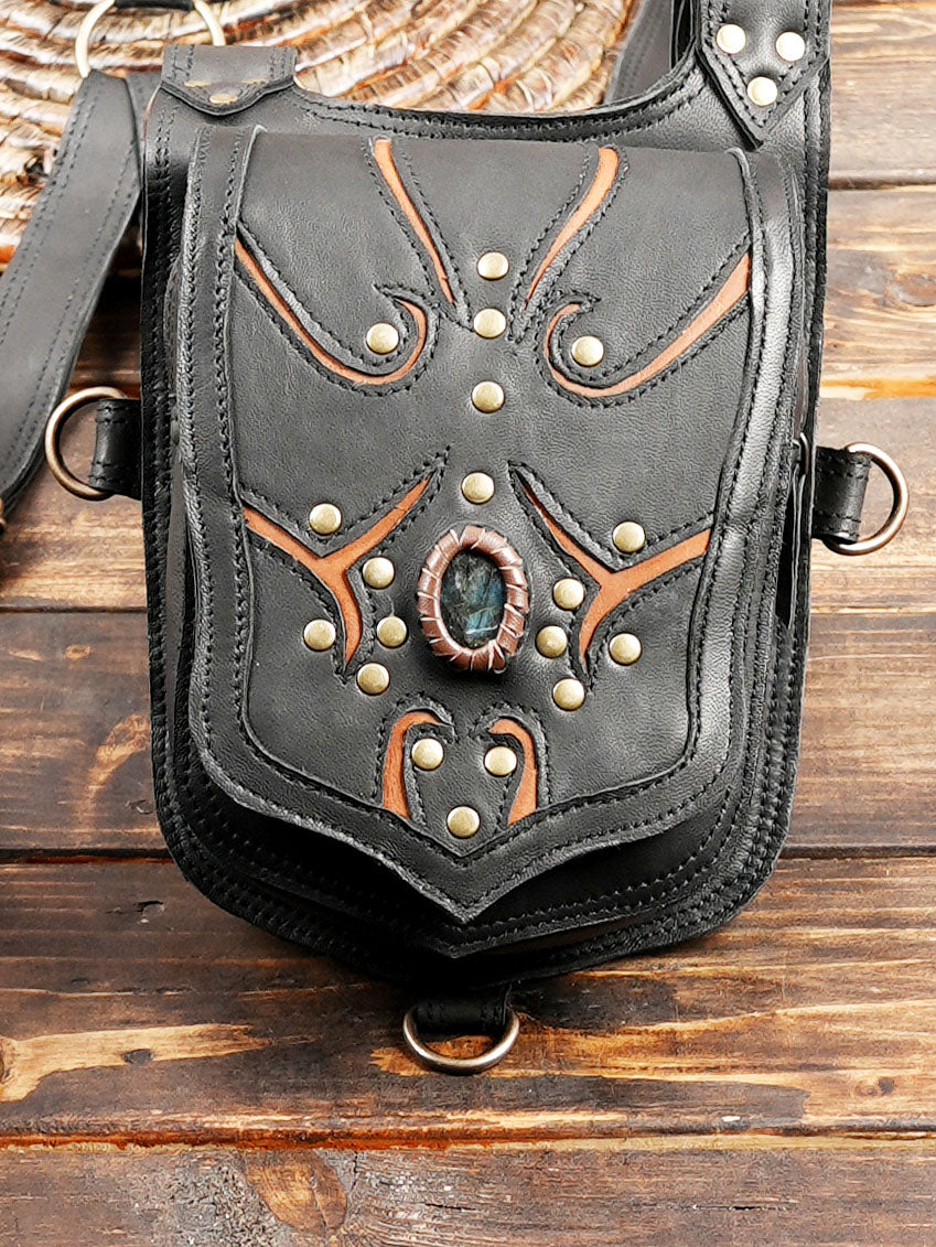 Black leather shoulder harness bag with blue gem