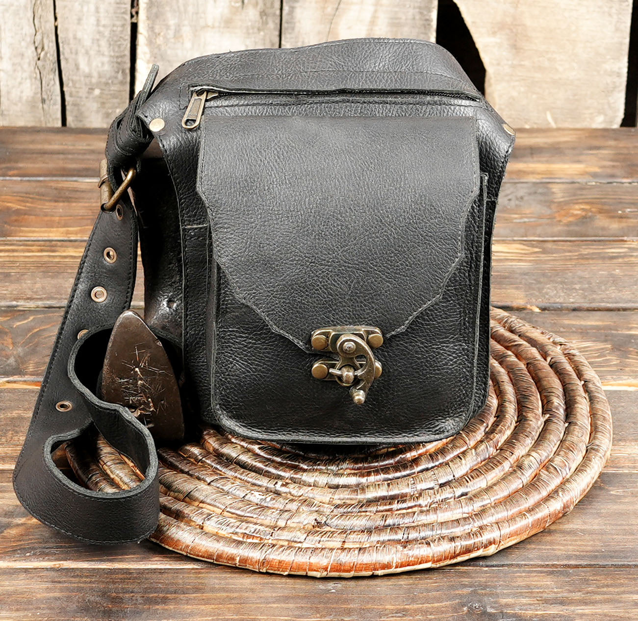 Stylish black waist bag featuring a front pocket and retro brass clasp