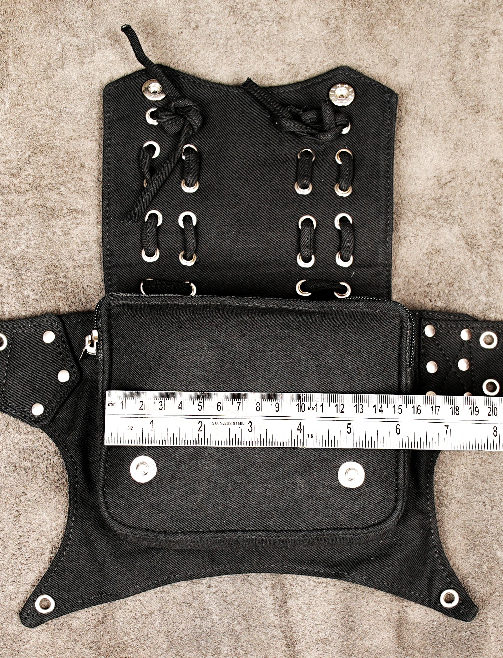 Adventure travel waist pack for hands-free carrying, in black canvas with studs.