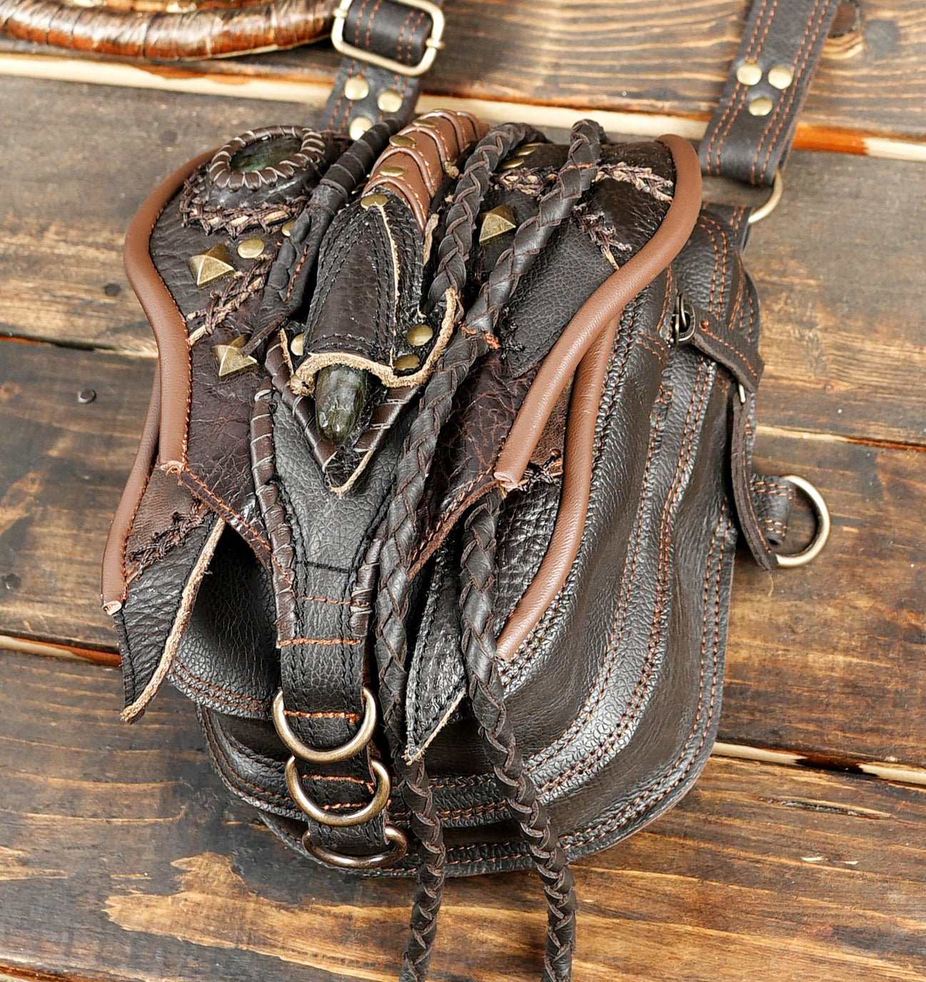 “Tribal-inspired leather shoulder holster with braided straps and decorative stones”