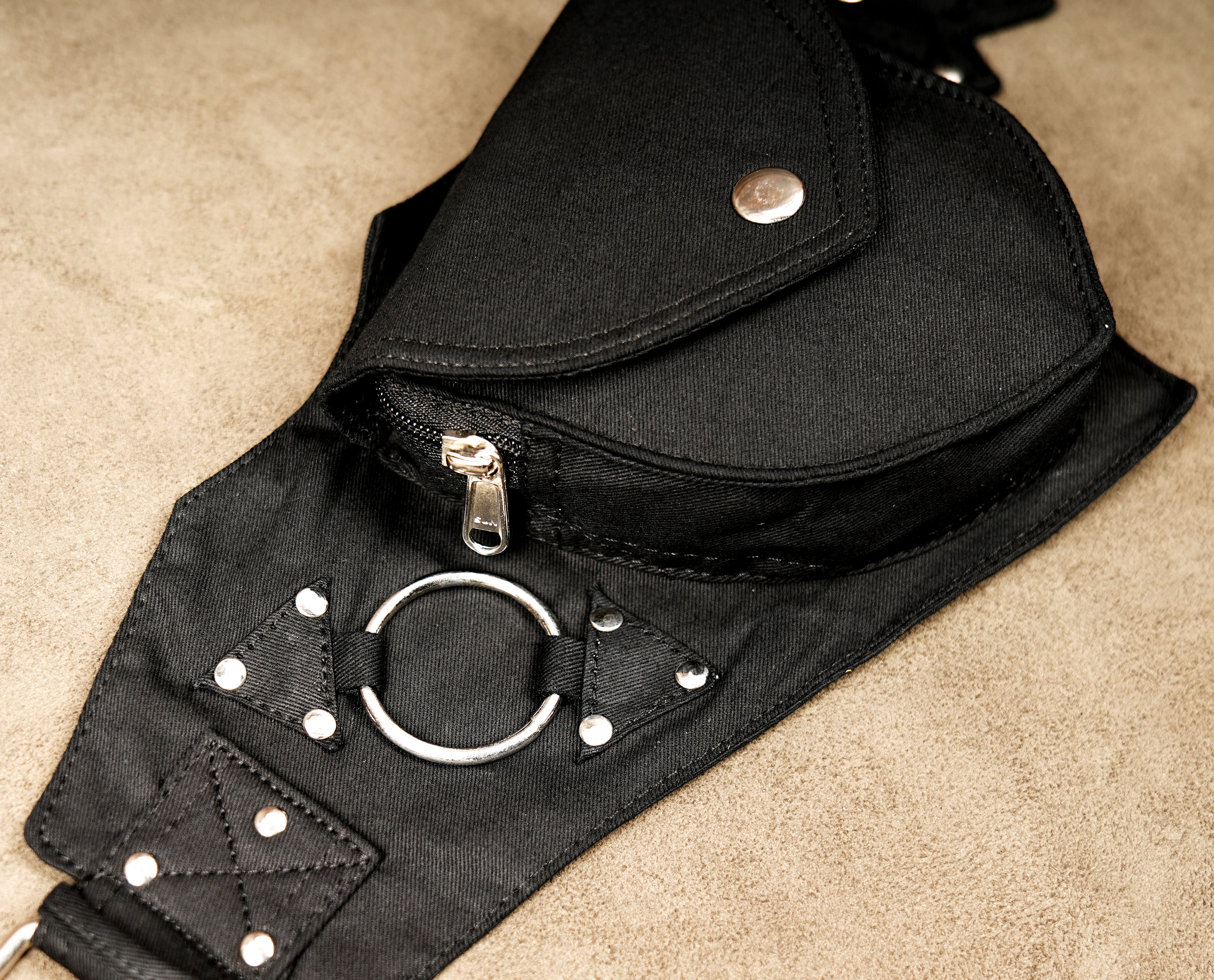 Unisex black hip belt bag featuring secure snap-button pockets and silver buckle.