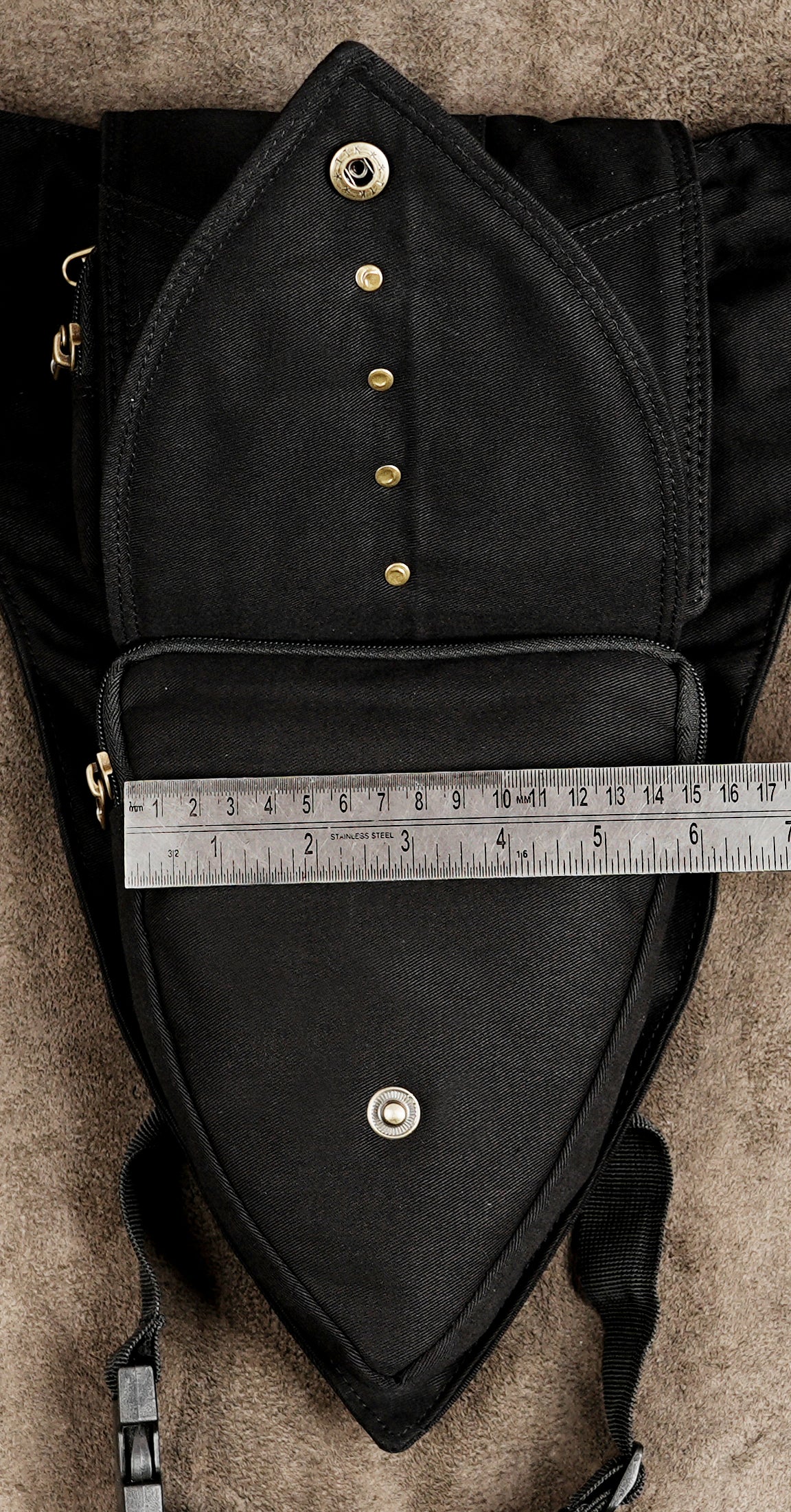 Close-up of antique brass studs on black cotton utility belt