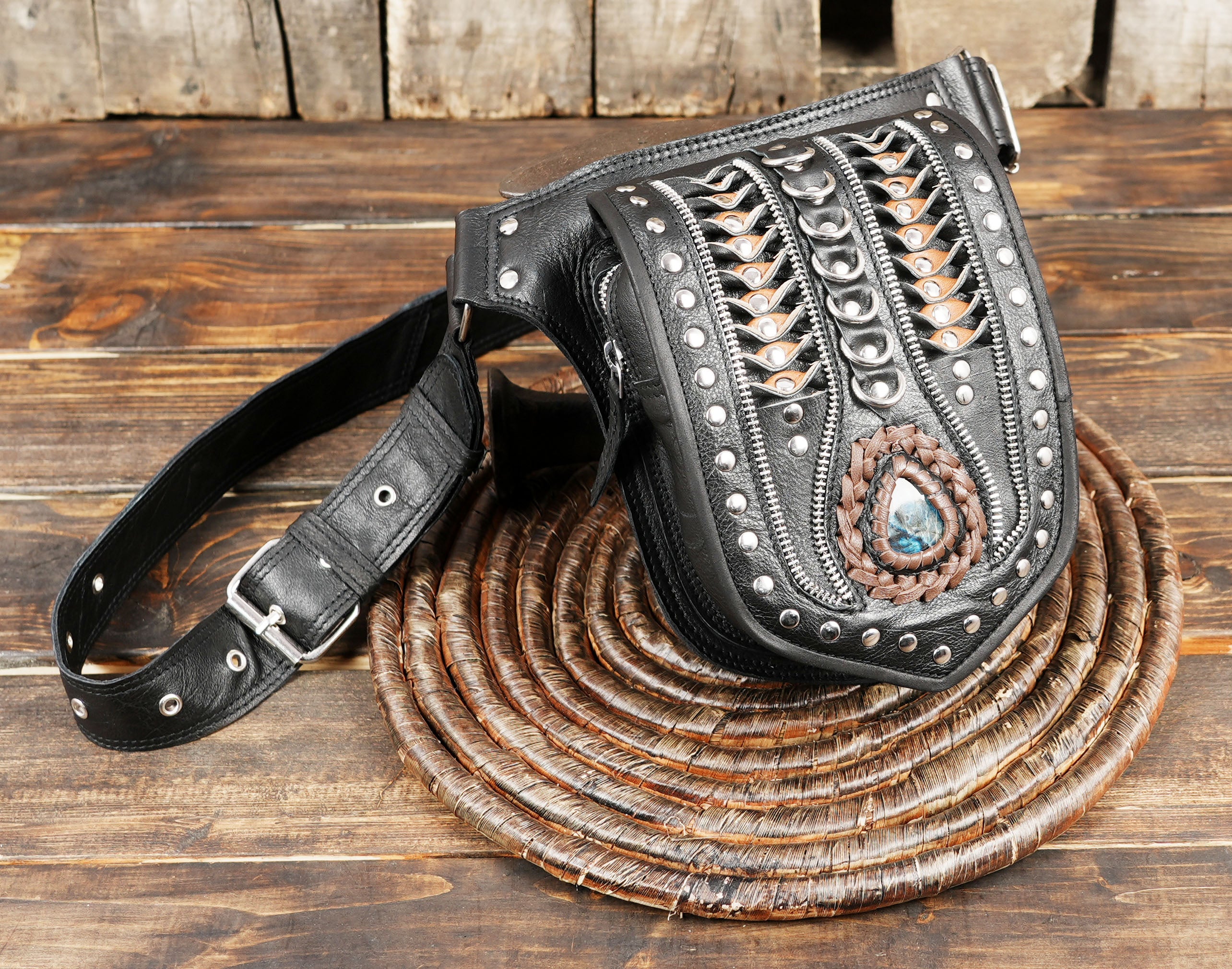 Handcrafted black leather waist belt bag featuring gothic metal studs, intricate braided leather panels,
