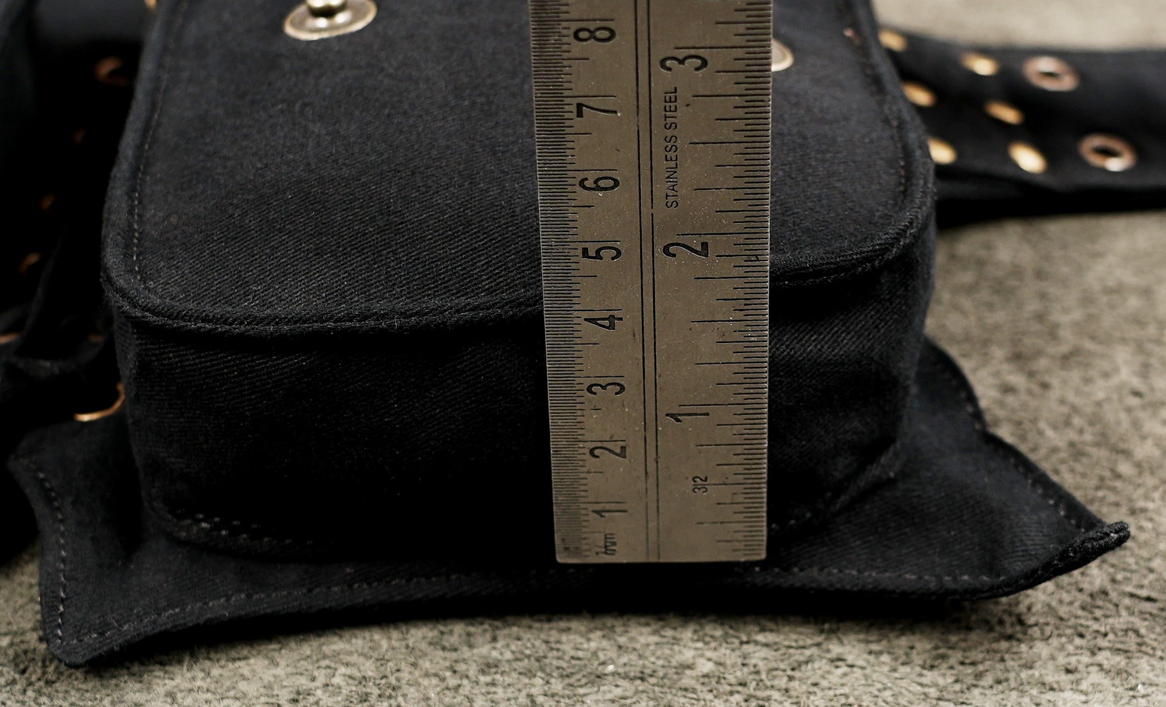 Black cotton tool belt with several pouches and secure zip closures