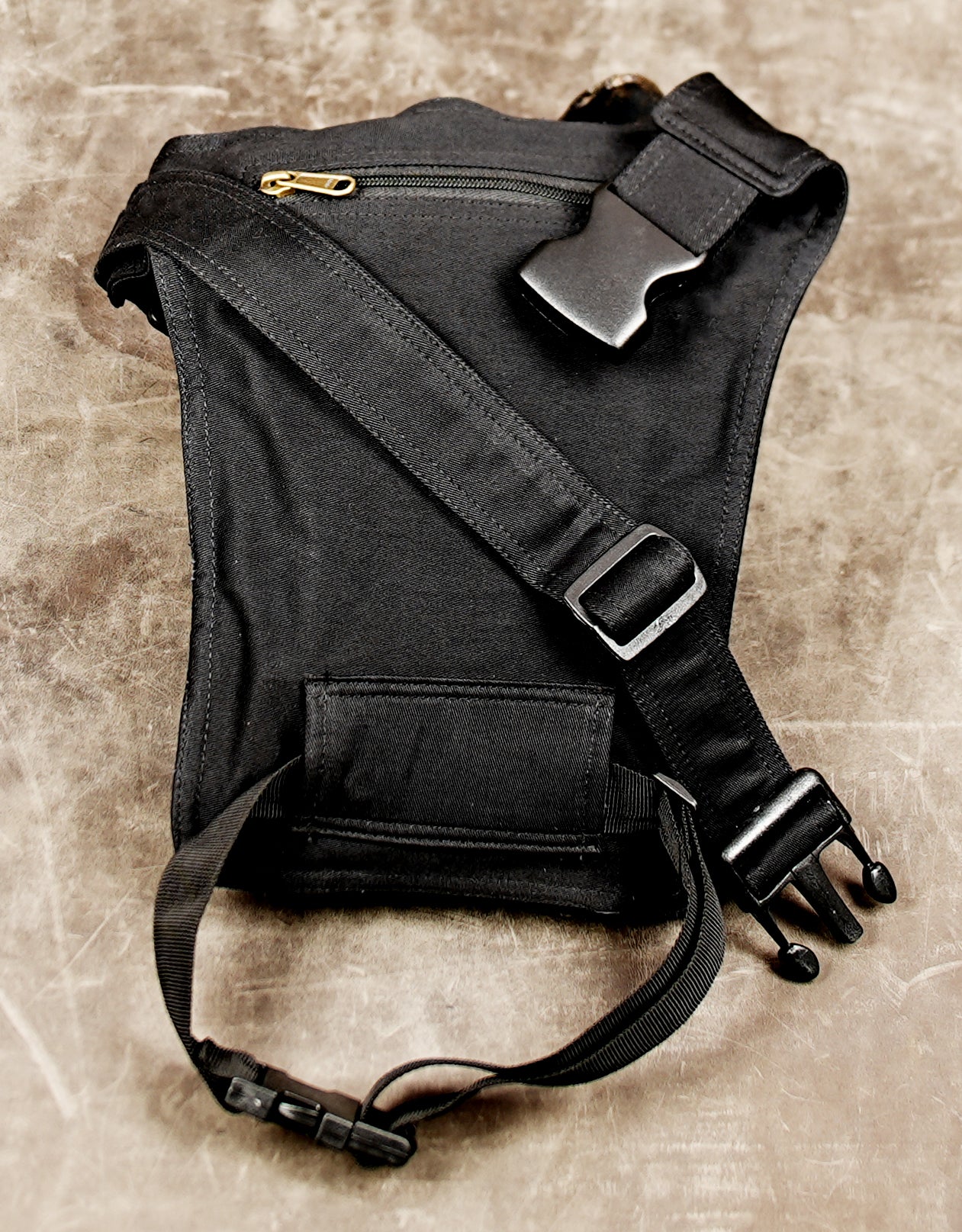 Black thigh pouch bag with secure buckle closure and flap pocket.