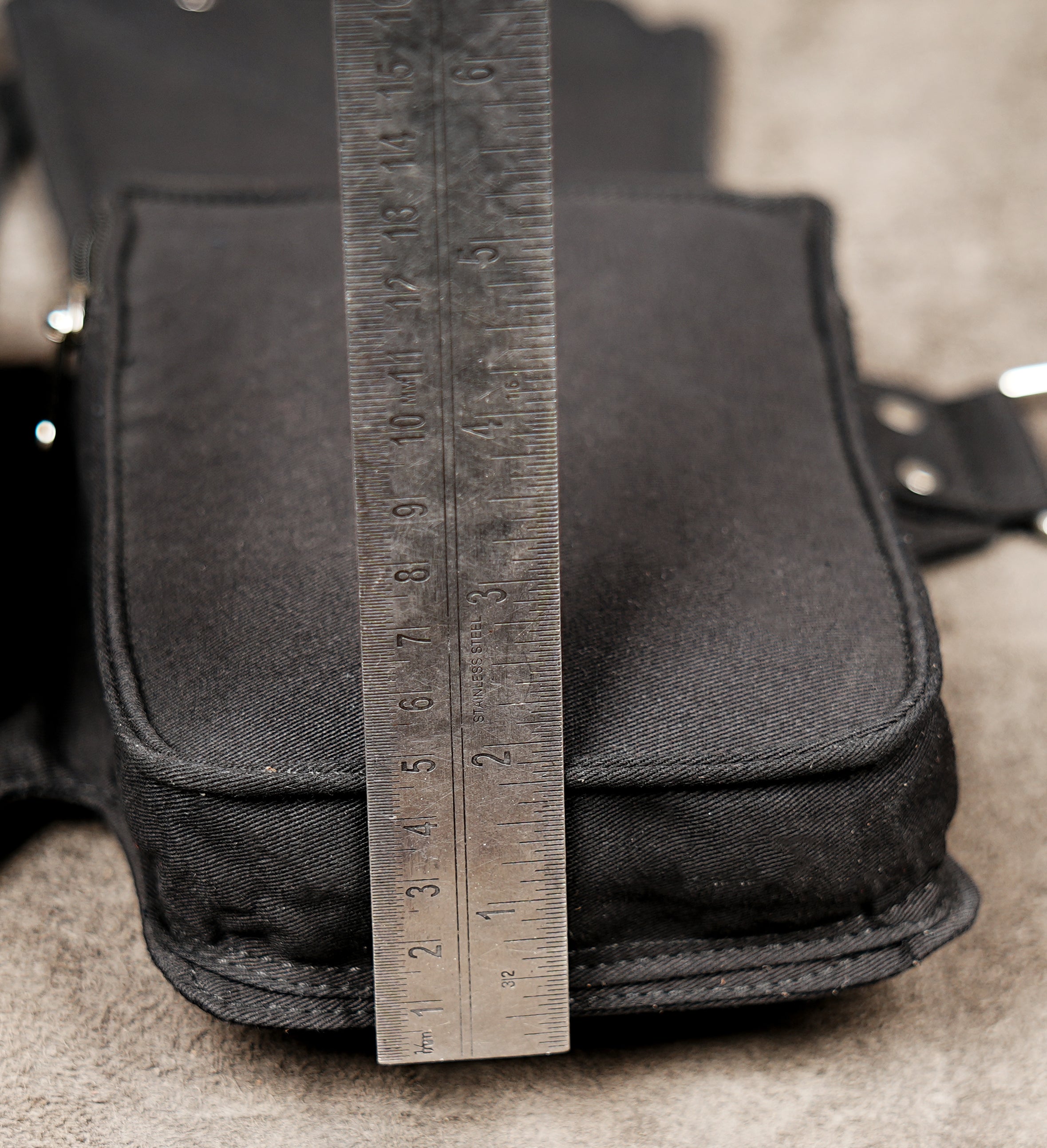 Adventure travel waist pack for hands-free carrying, in black canvas with studs.