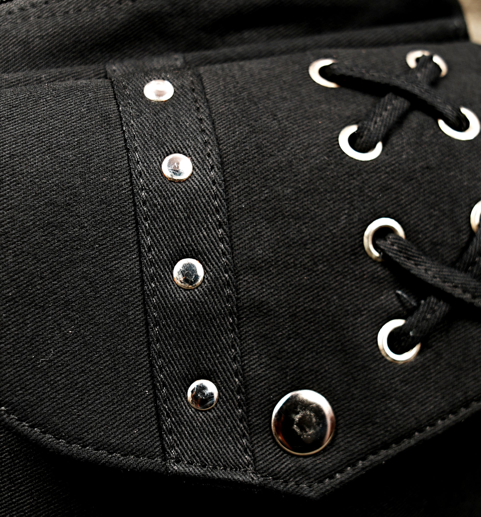 Black cotton waist belt bag with lace-up pocket detail and silver-tone hardware for boho festival style.