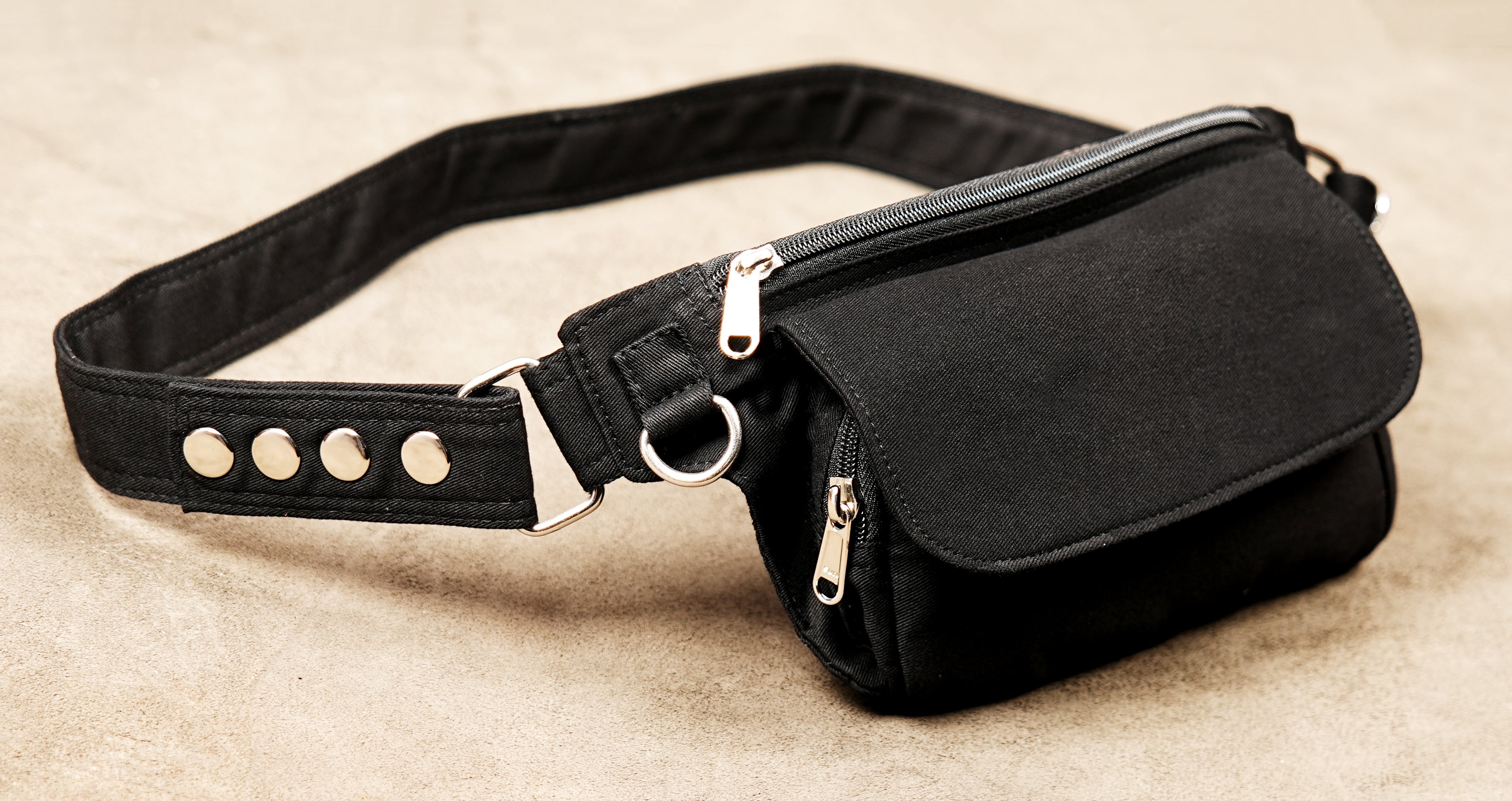 Minimalist black cotton fanny pack with an adjustable waist strap and secure pocket.