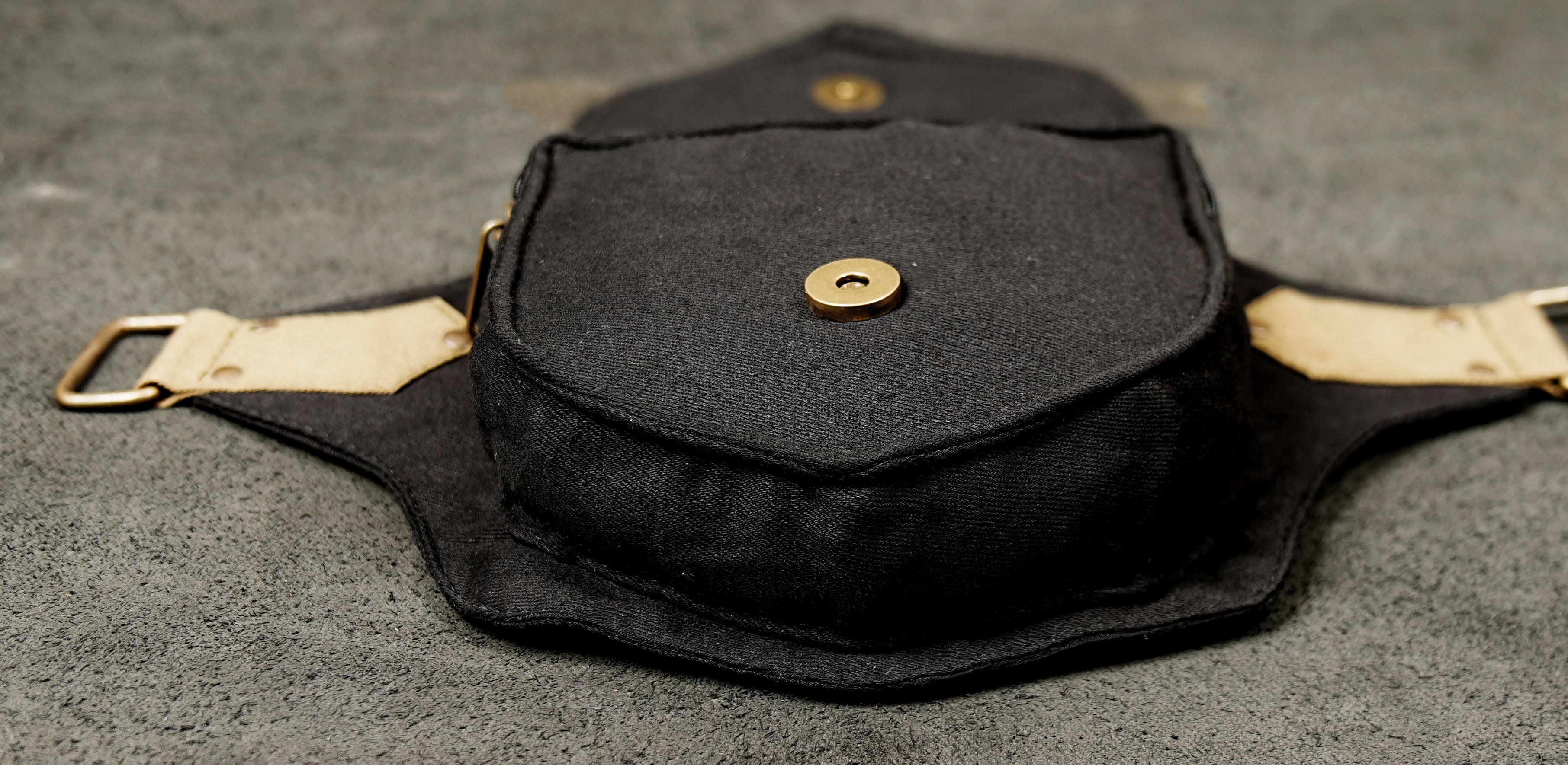 A black and cream (two-tone) cotton hip pack, combining fashion and practical storage.