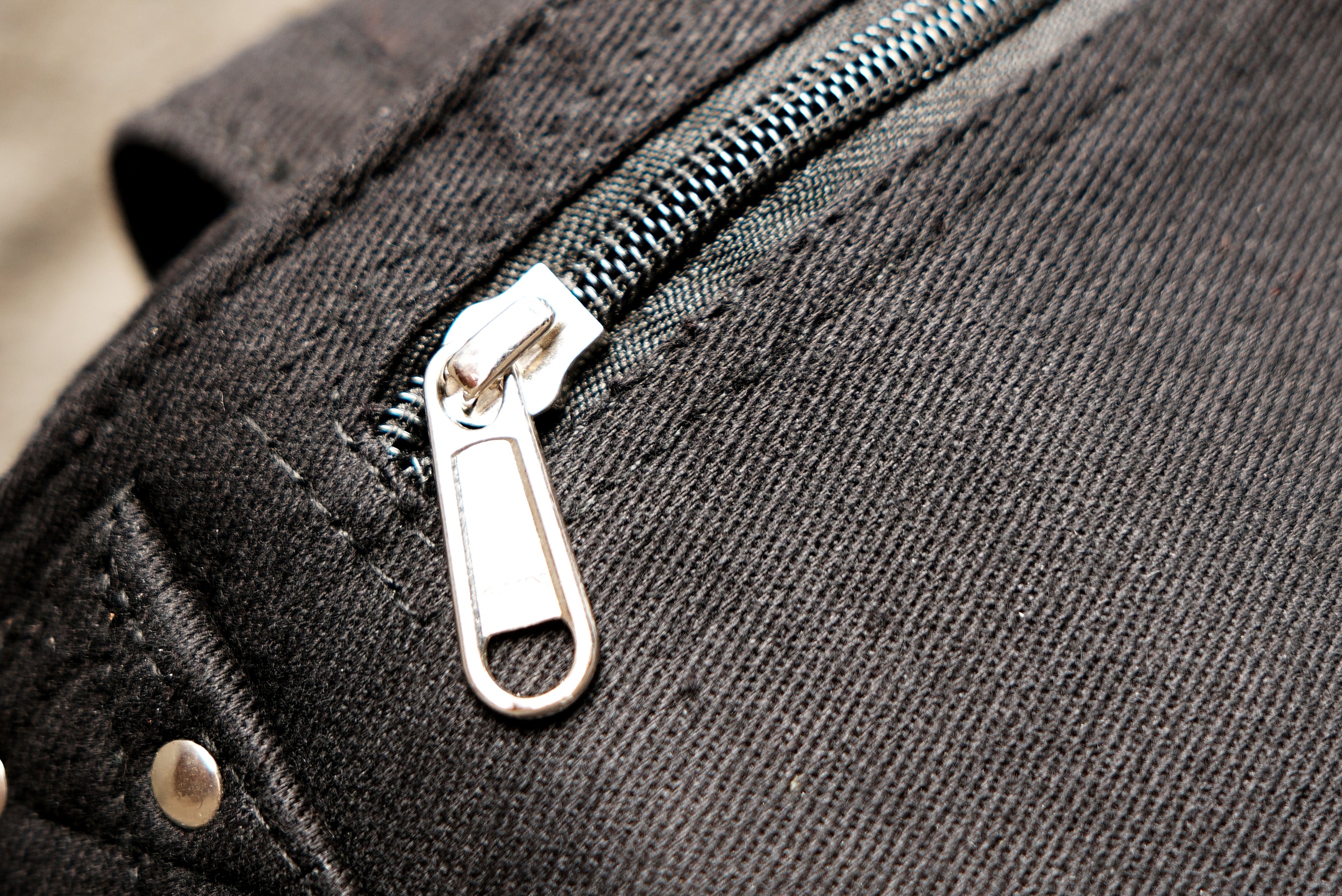 An alternative style utility fanny pack with secure metal riveted details and durable stitching.