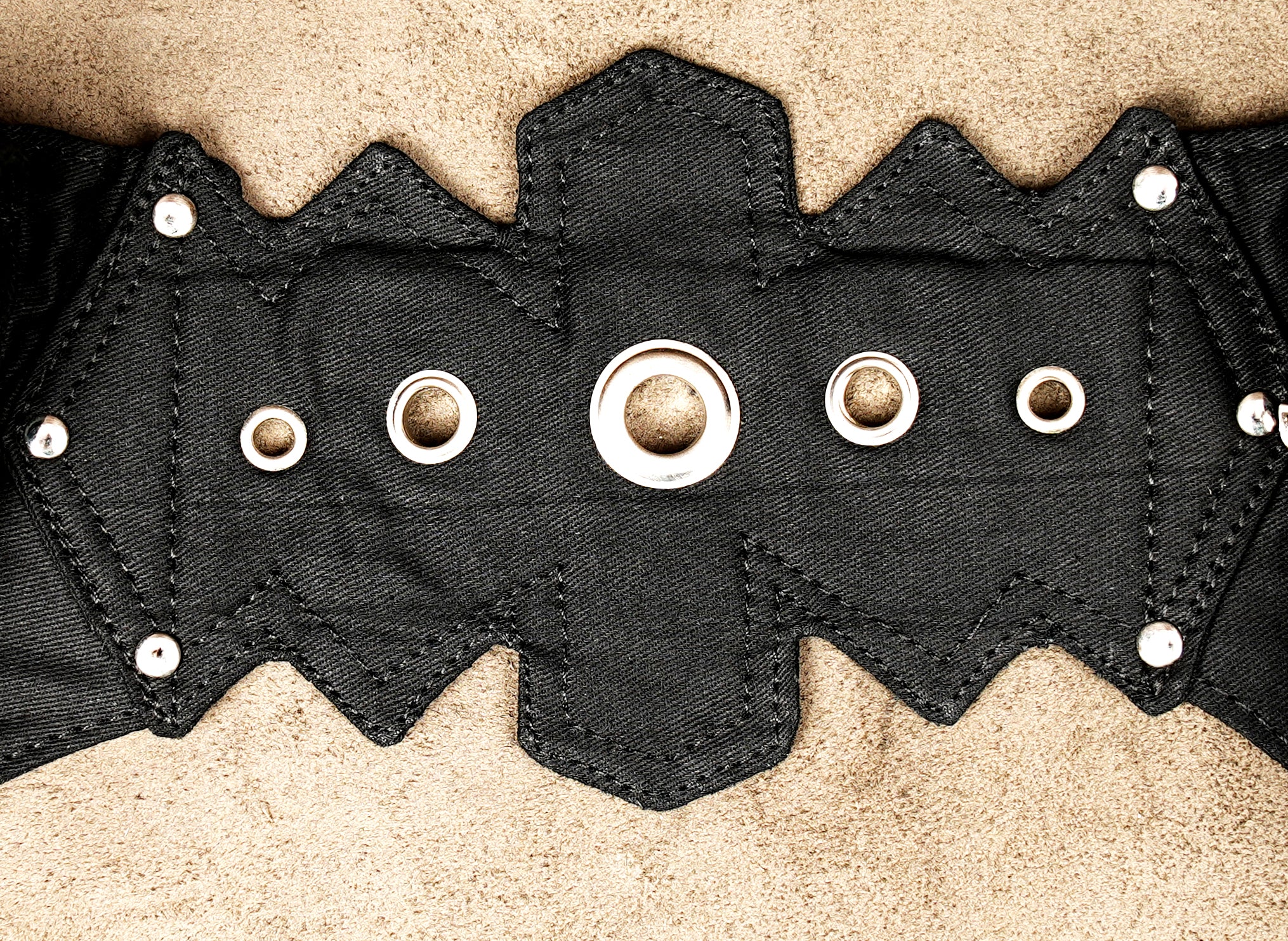 Leather-style black hip bag with attached studded waist strap and O-rings.