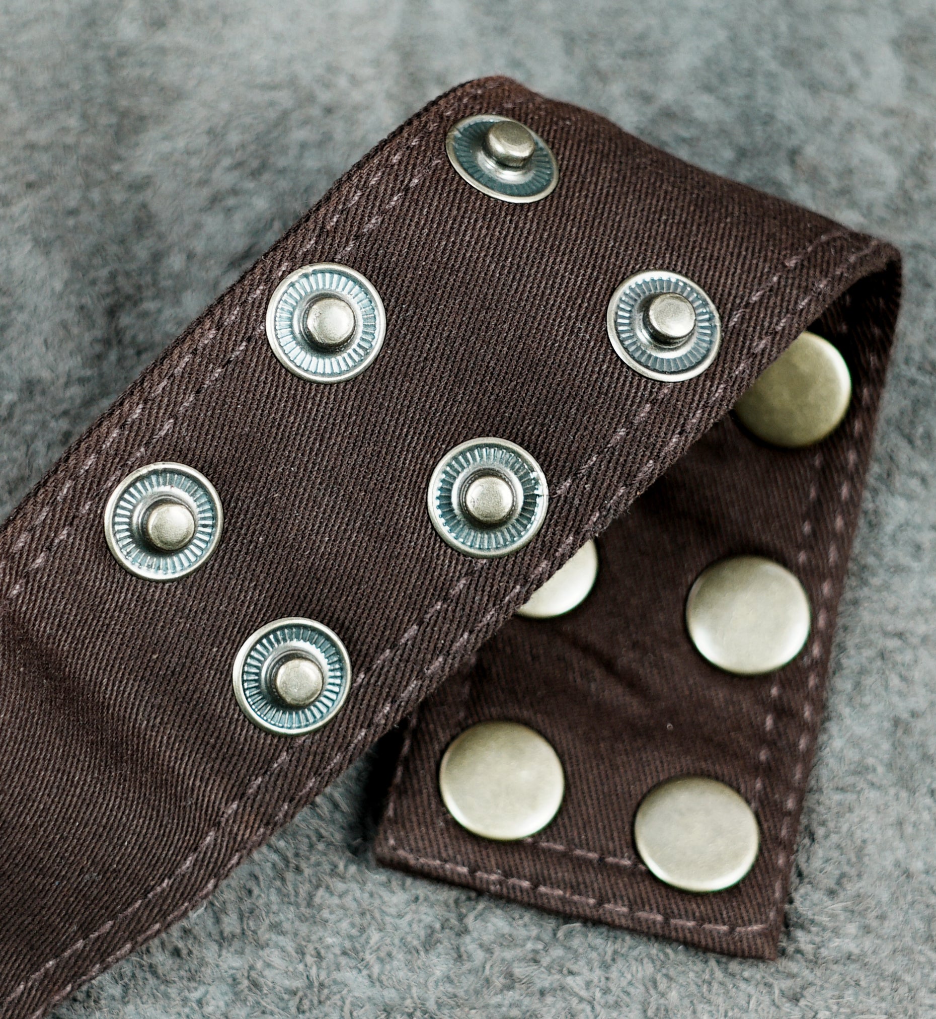 Brown hip pouch with lace overlay, snap closures and zip pockets