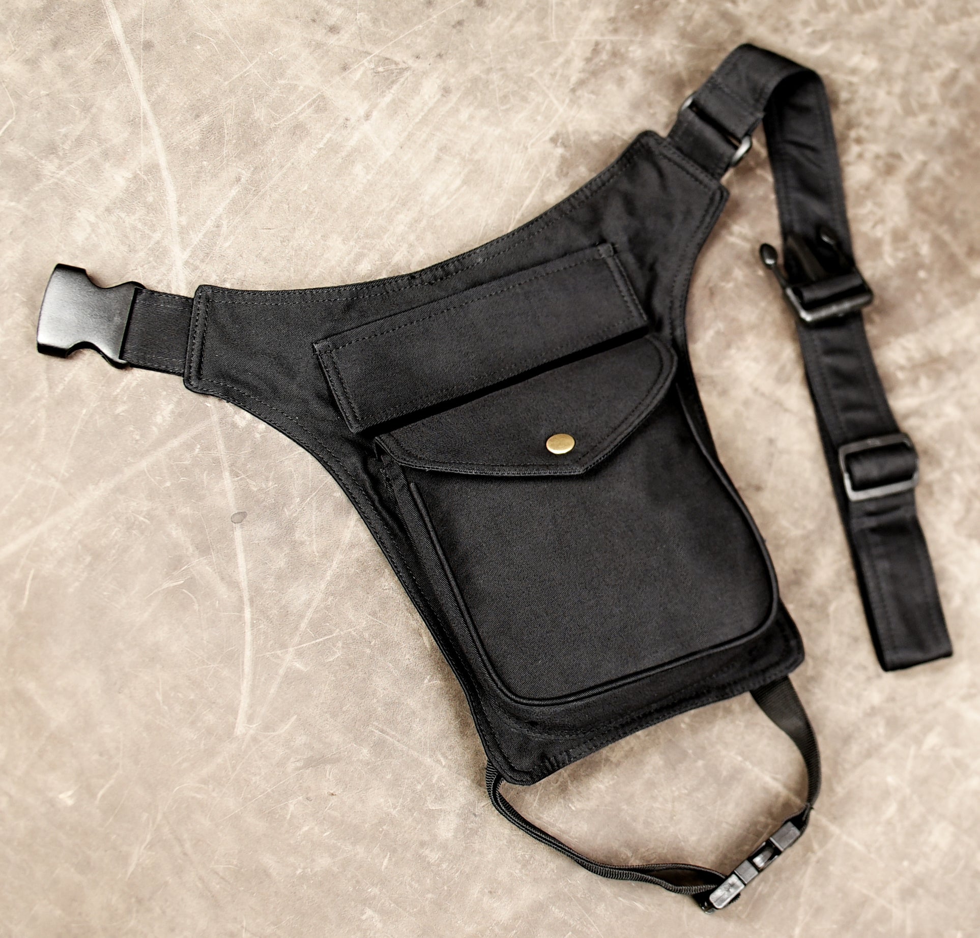 Black hands-free hip bag with multiple pockets and leg strap.