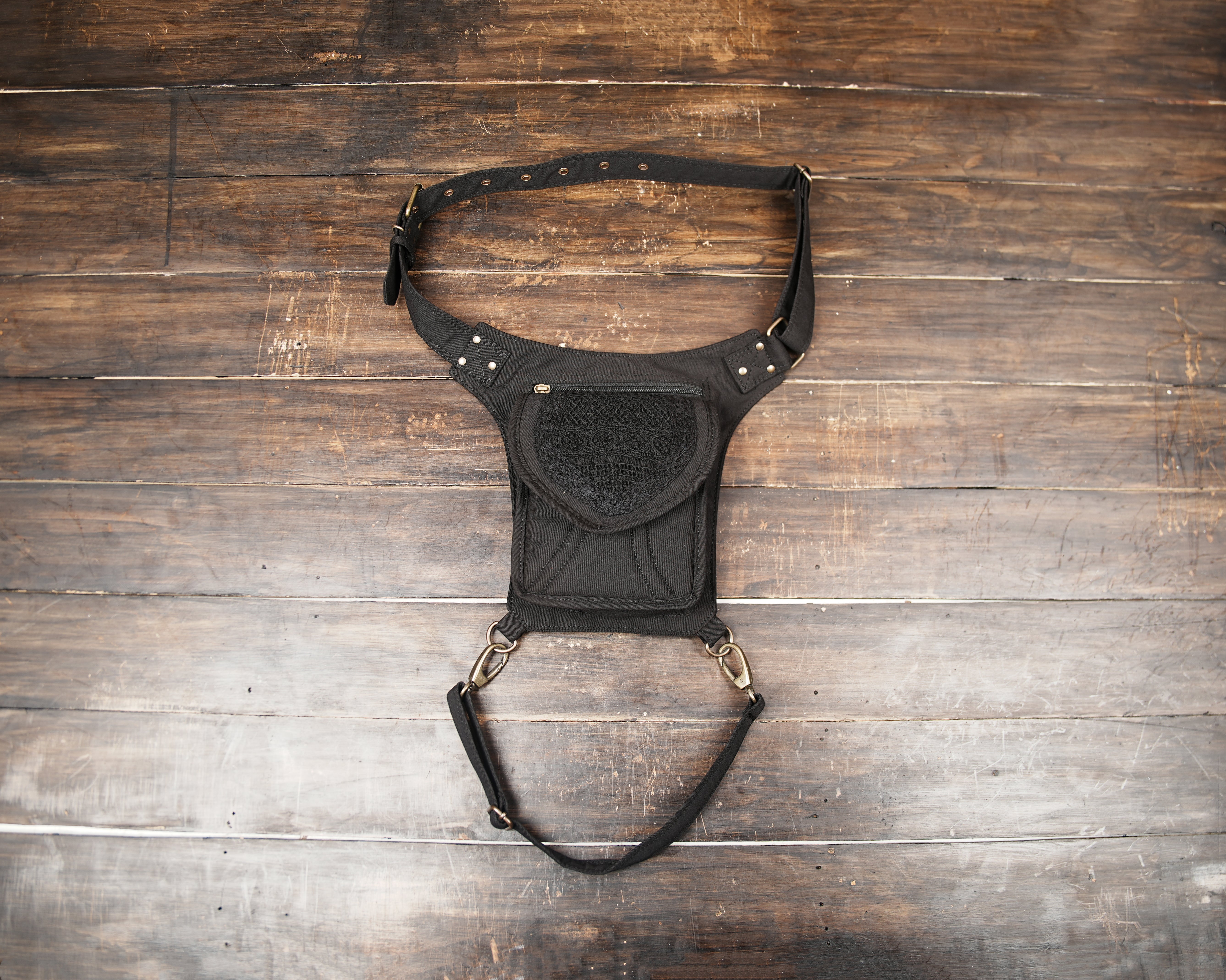 Handmade cotton canvas drop leg bag with dark floral lace flap and brass grommet waist belt.