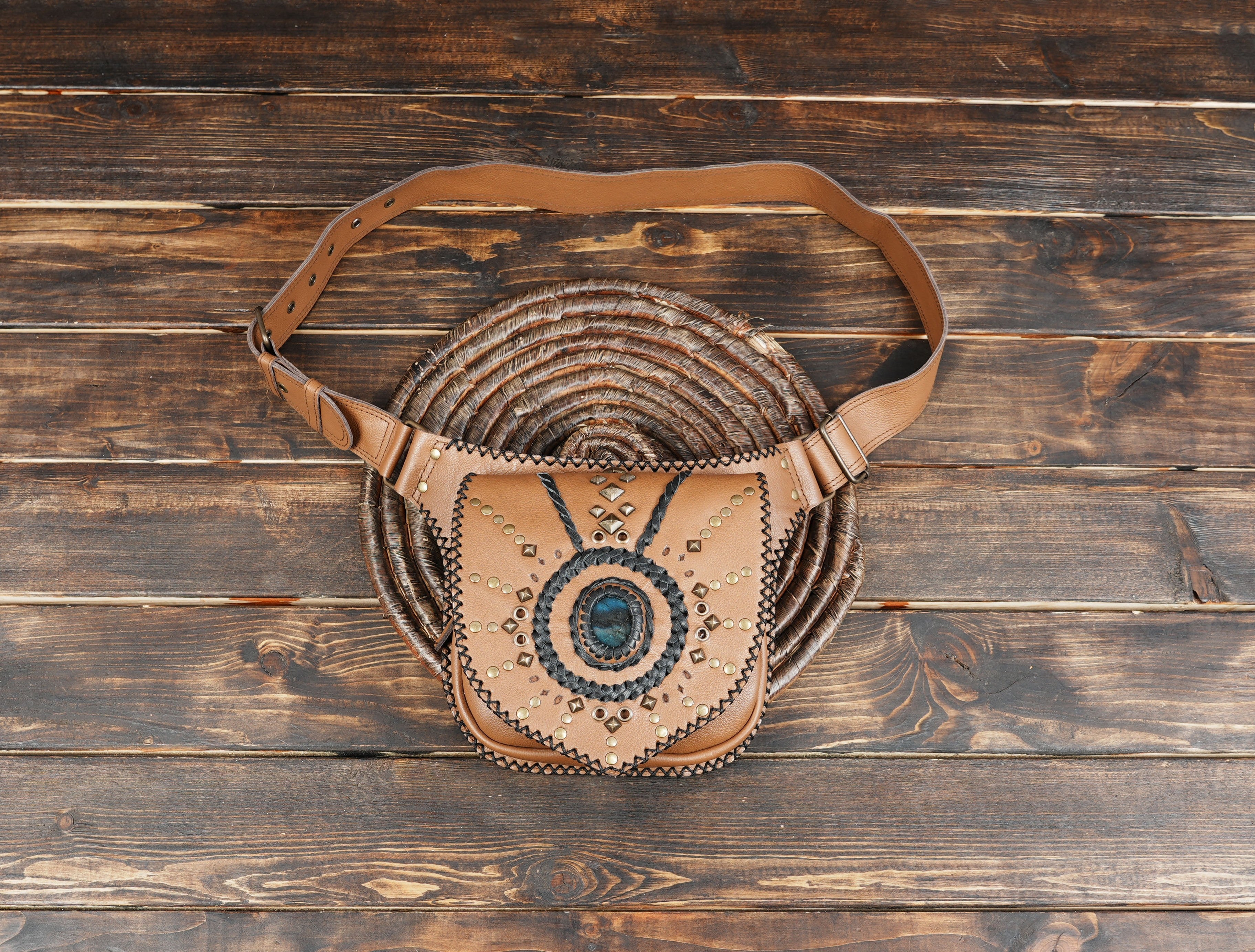Tan leather utility belt bag with gemstone centerpiece and black braided details