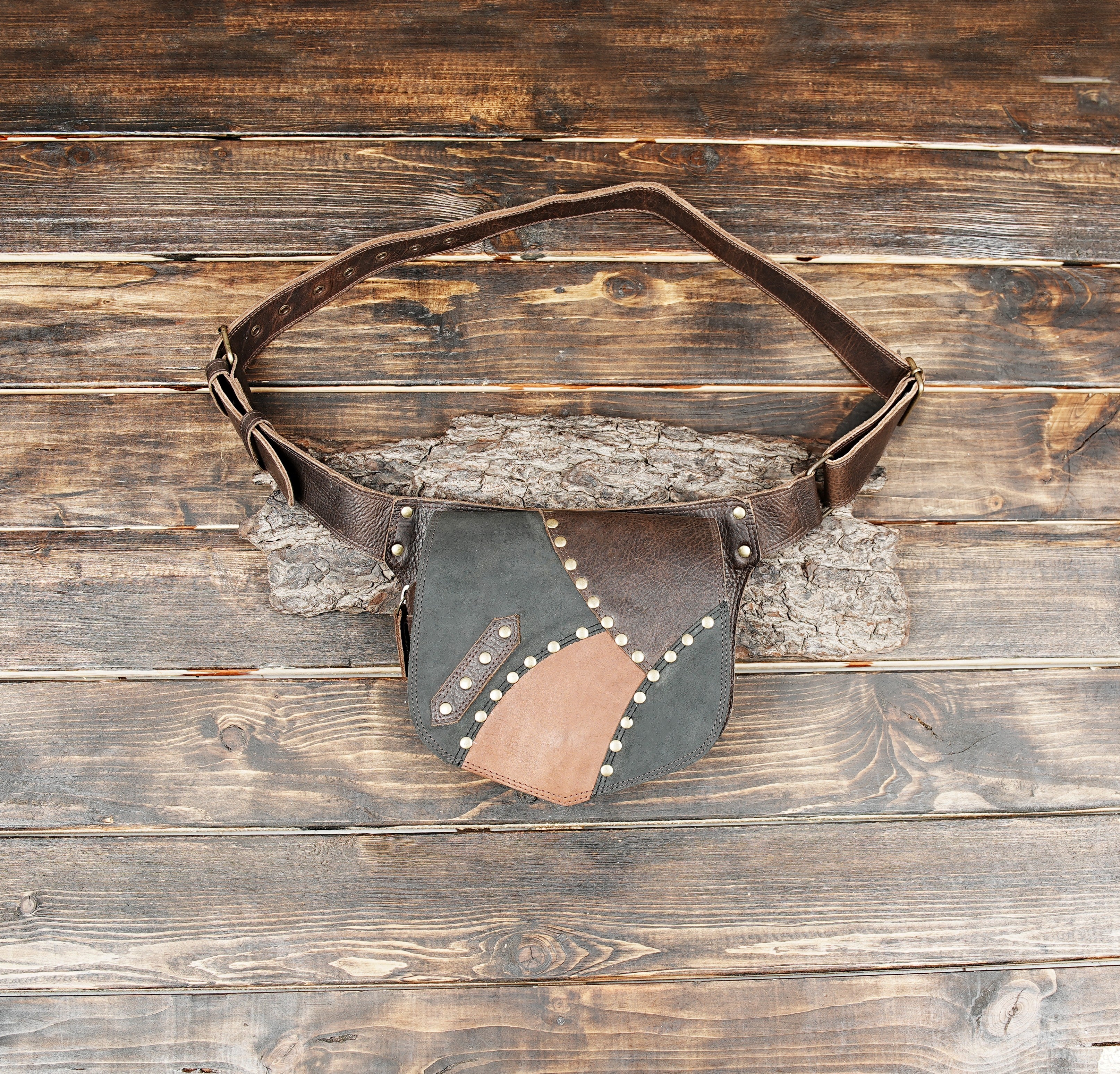 Close-up of handmade leather waist pouch with brass stud details