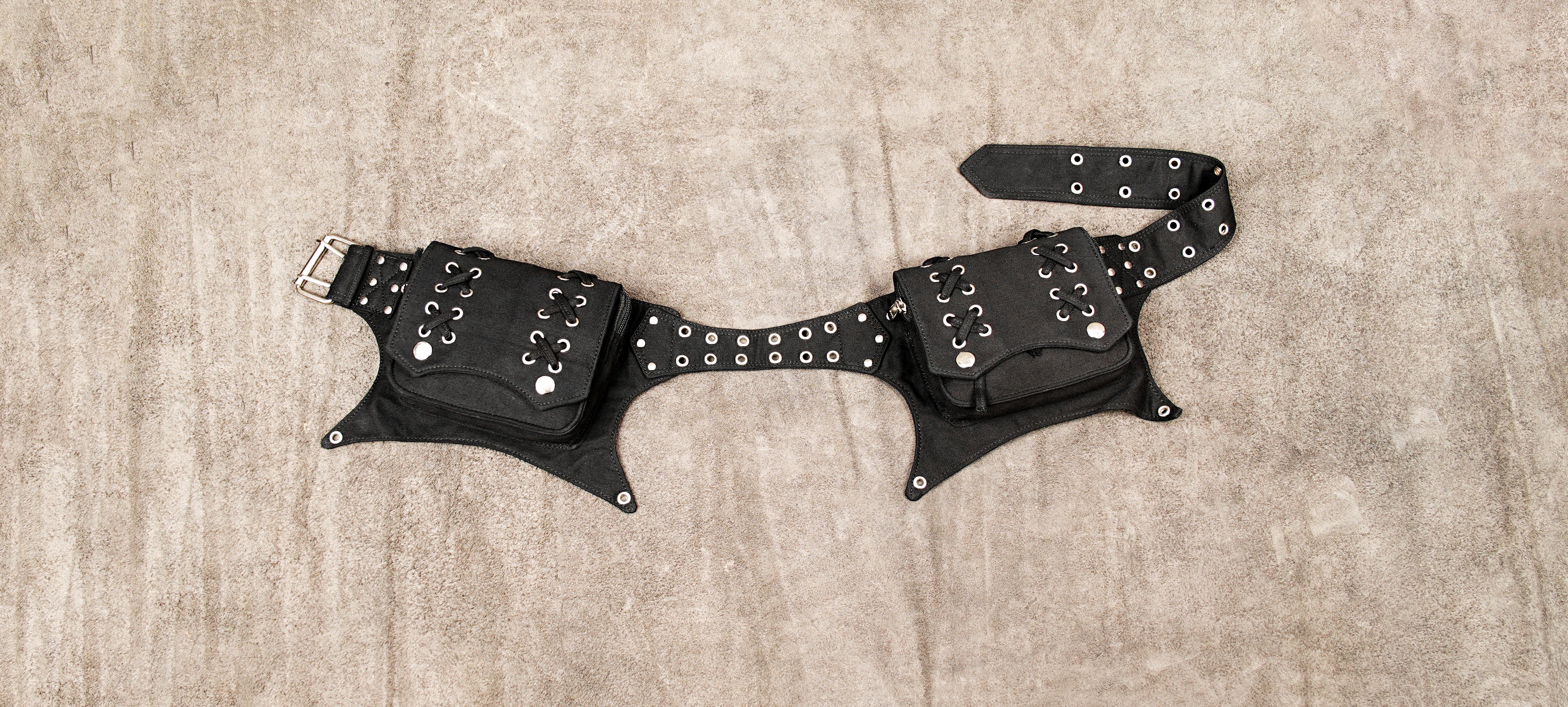 Black canvas utility belt with multiple pouches and metal studs.
