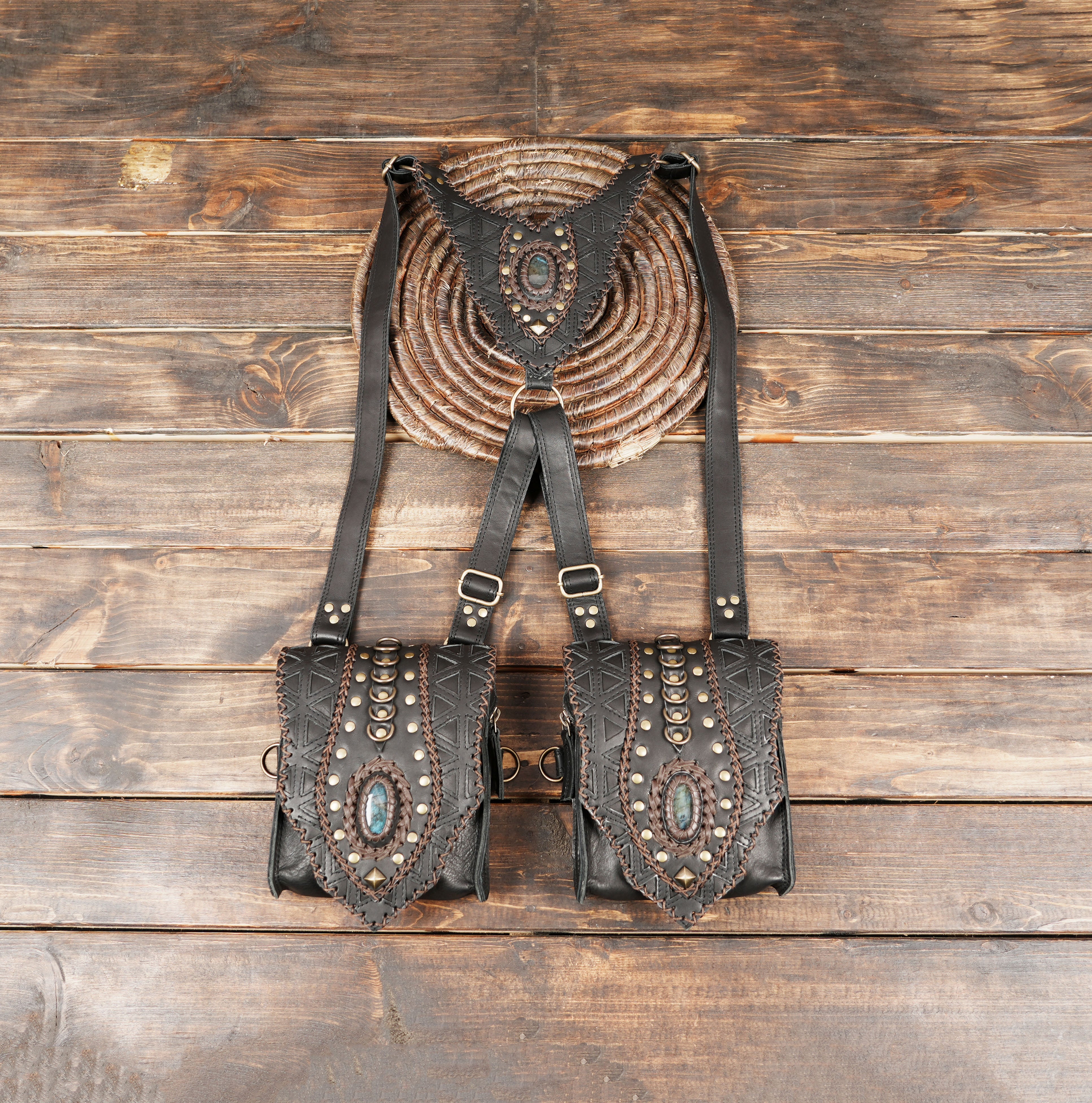“Handmade black leather holster harness with geometric tooling and gemstone accents”