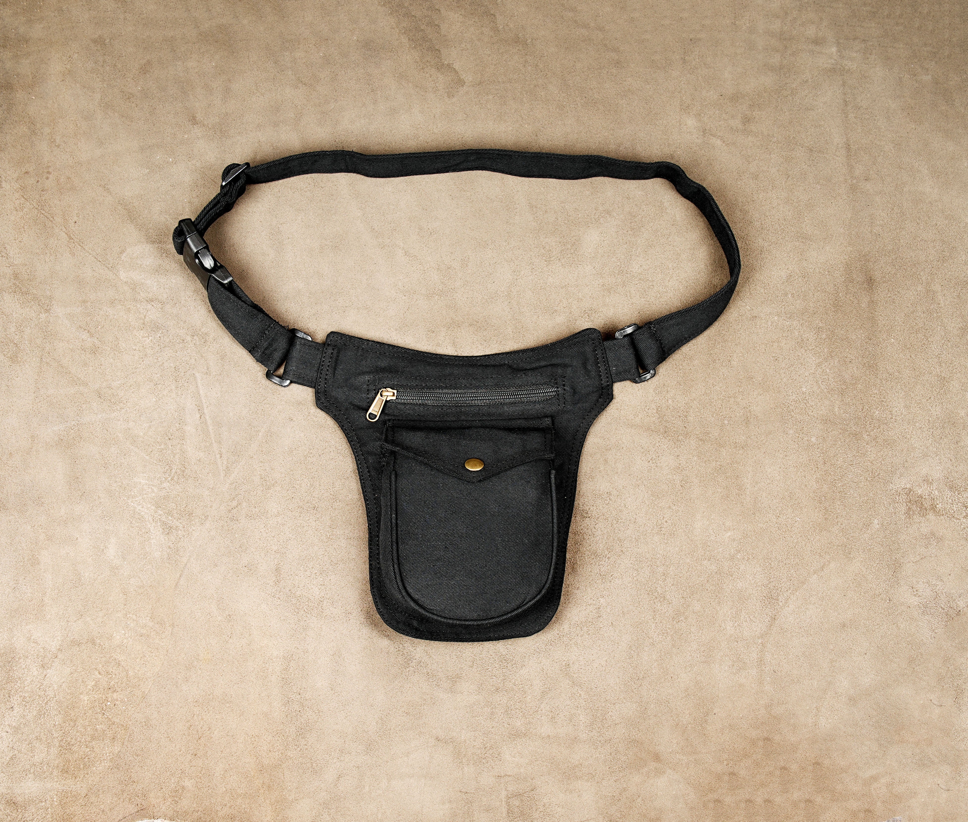 Black cotton waist bag with adjustable strap laid flat