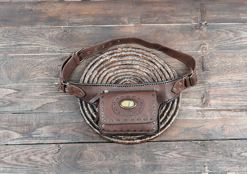 Handcrafted brown leather belt bag with natural stone accent and detailed stitching