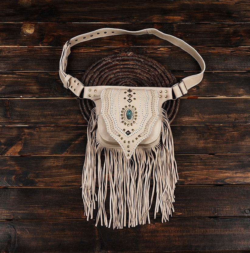 Cream leather waist belt bag with long fringes and turquoise stone centerpiece.