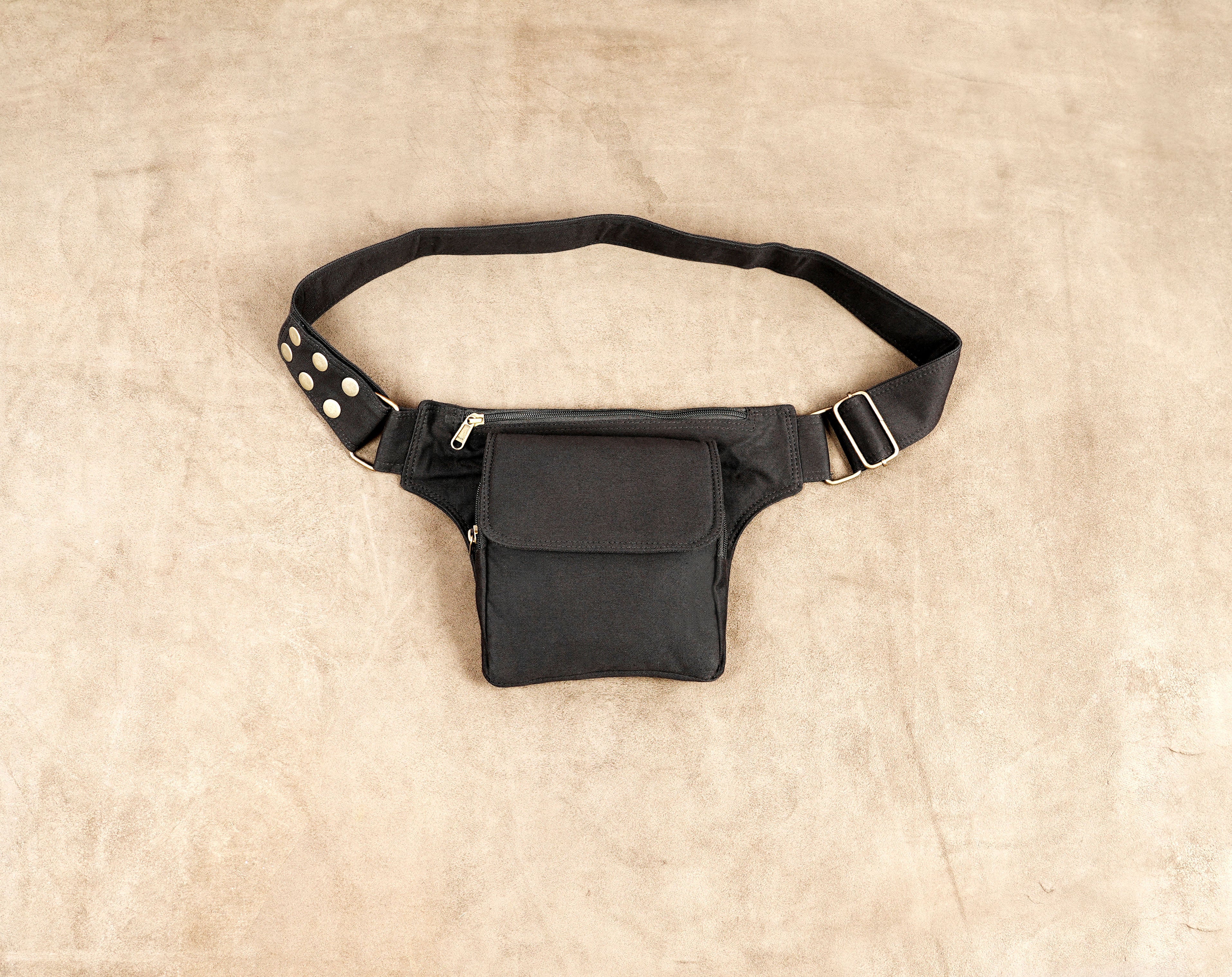 Black canvas waist belt bag with front flap pocket and brass zipper