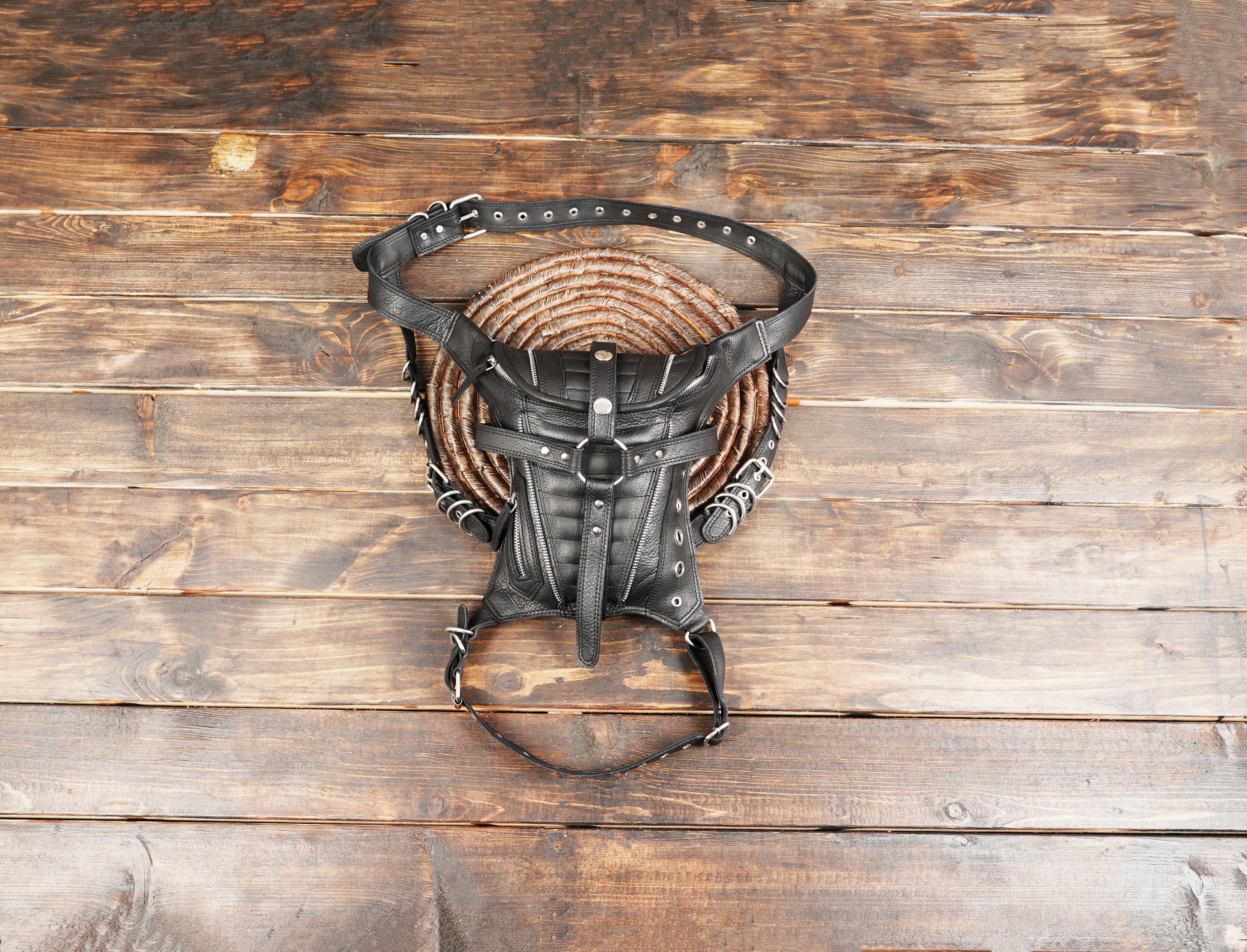 Stylish utility waist bag featuring a sleek black leather design and adjustable straps.