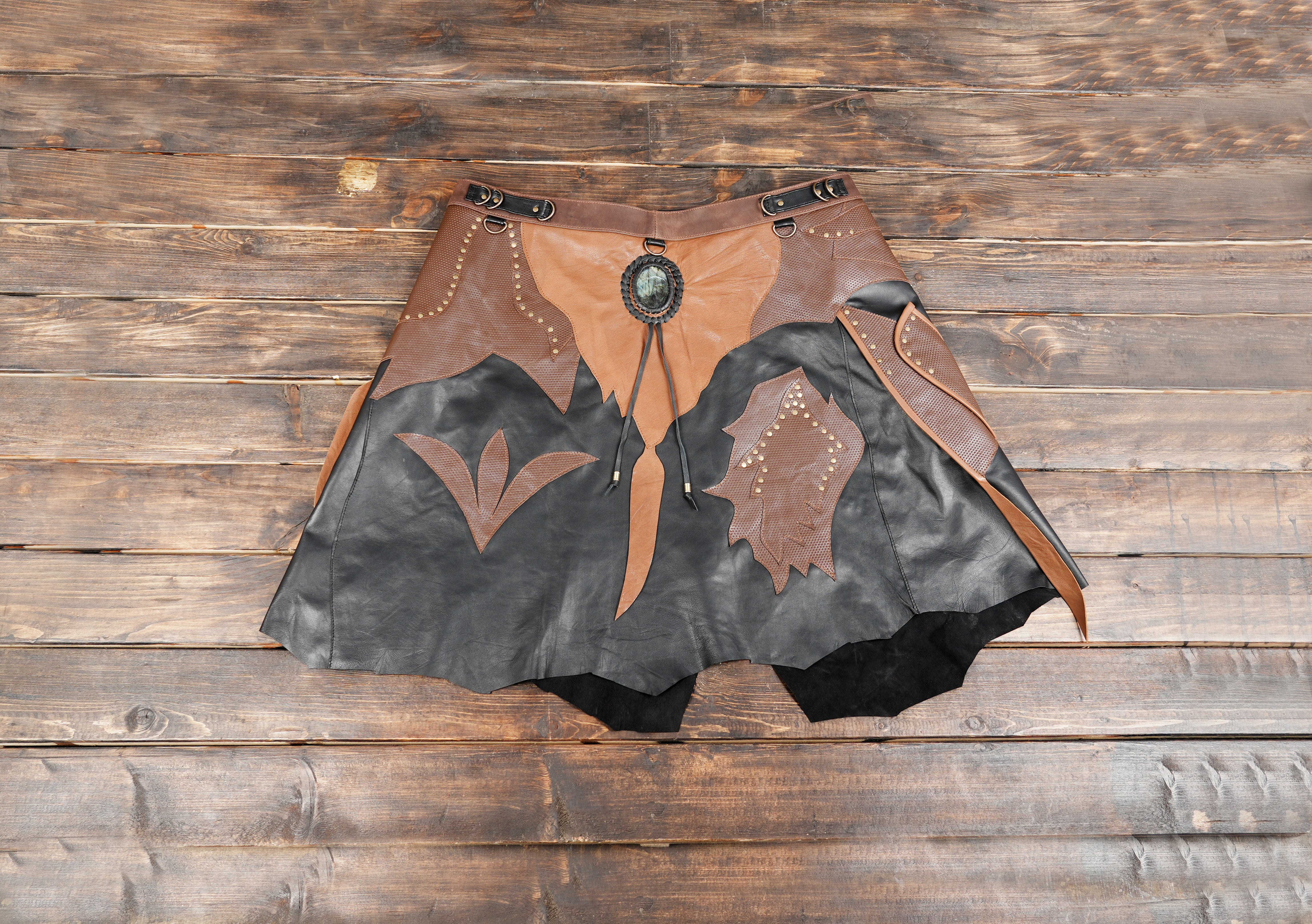 Handmade leather skirt with detailed panel design and decorative accents