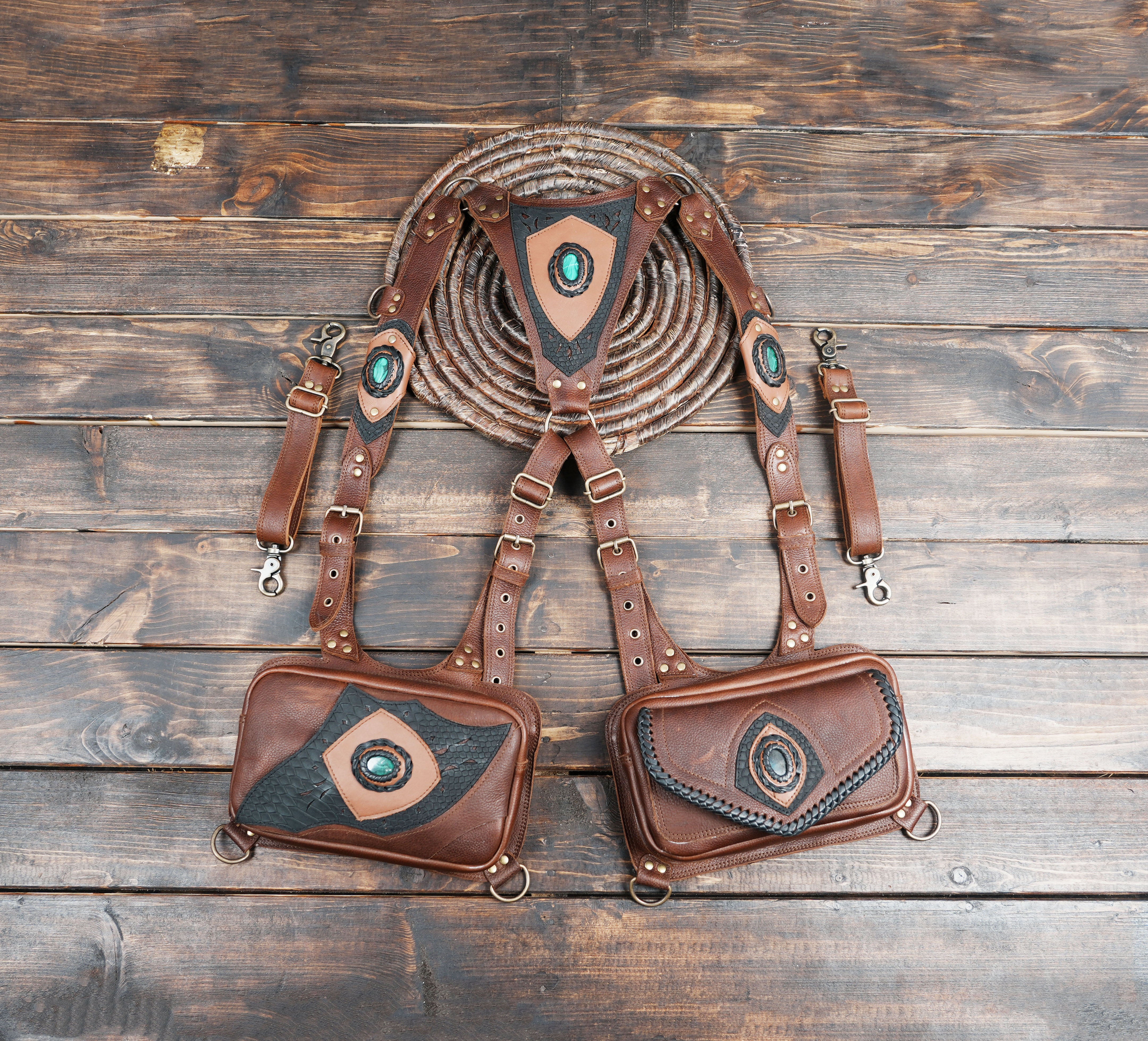 Brown leather shoulder holster bag with gemstone design on wooden background