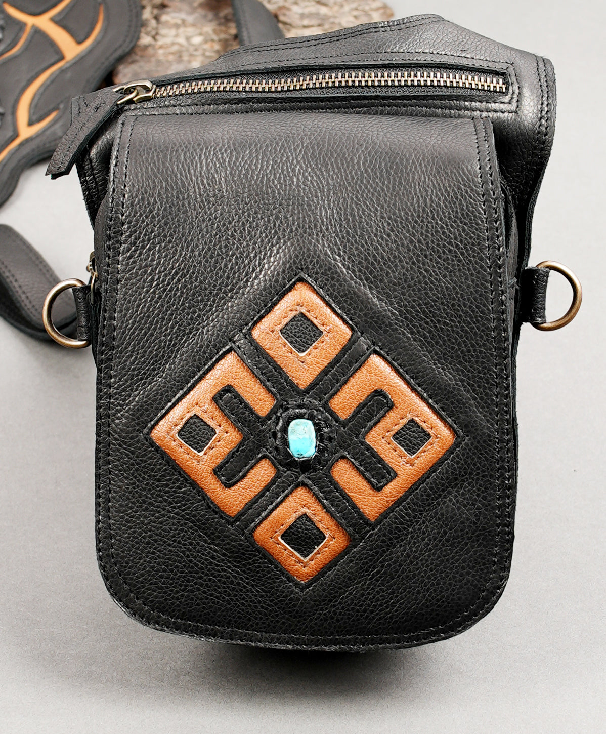 Double leather pouch harness for carrying essentials.