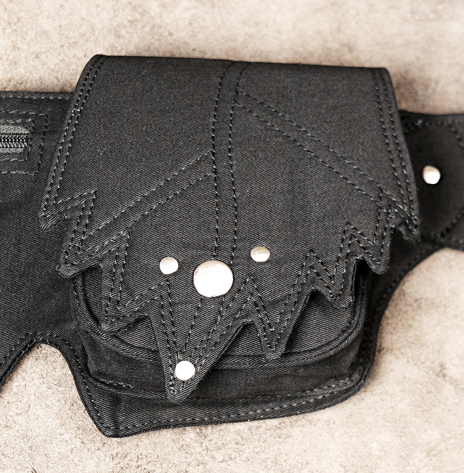 Adjustable waist pack with two large pockets and decorative grommet strap.