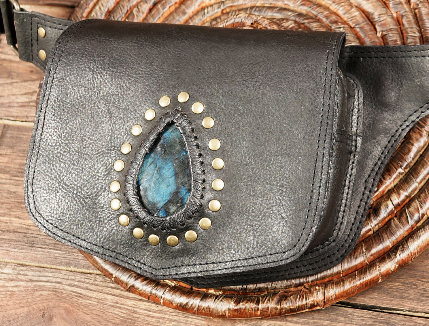 Handmade gemstone leather belt bag on rustic wood background