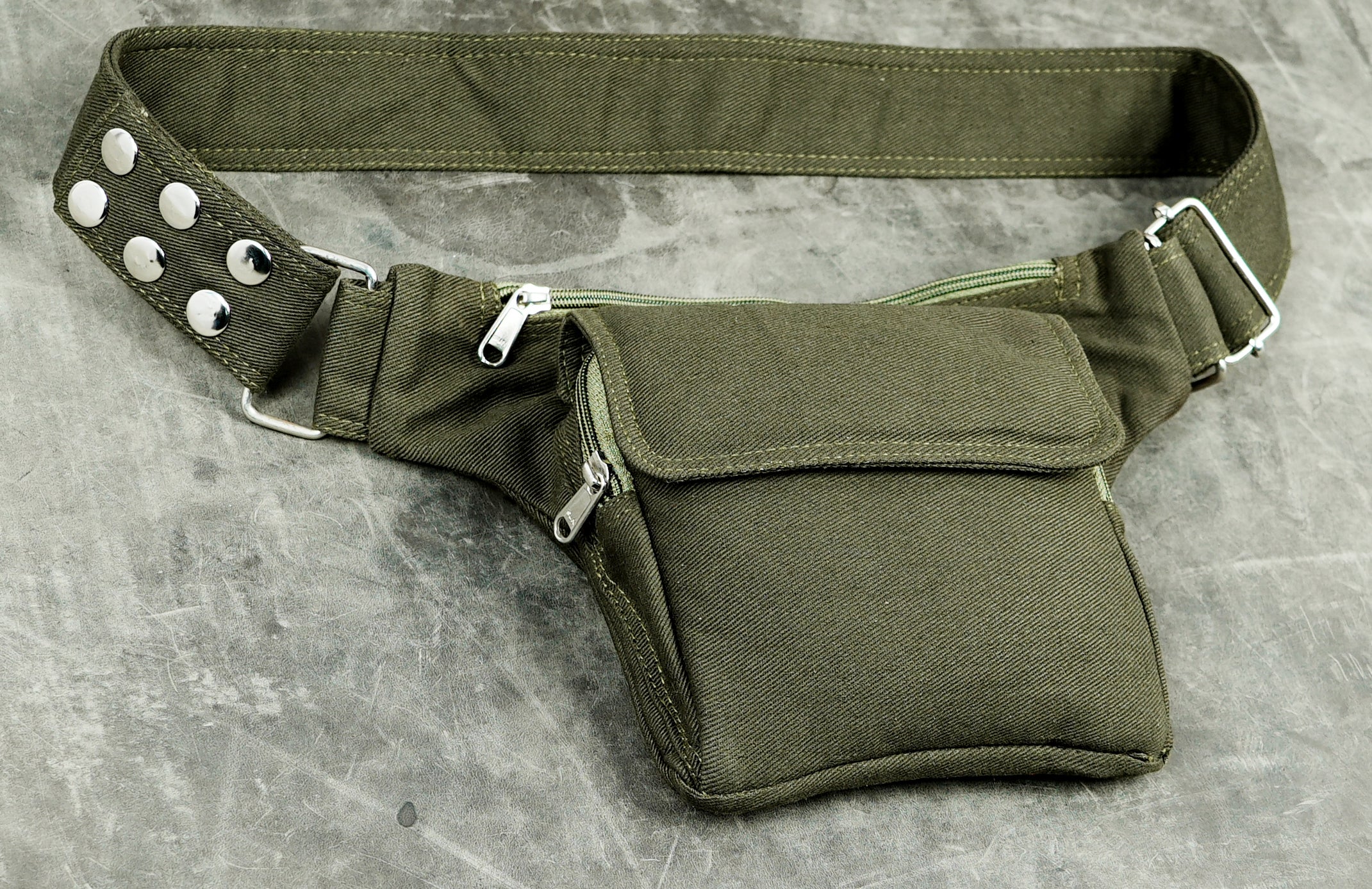 Army green waist pack with silver zipper pulls and flap pocket