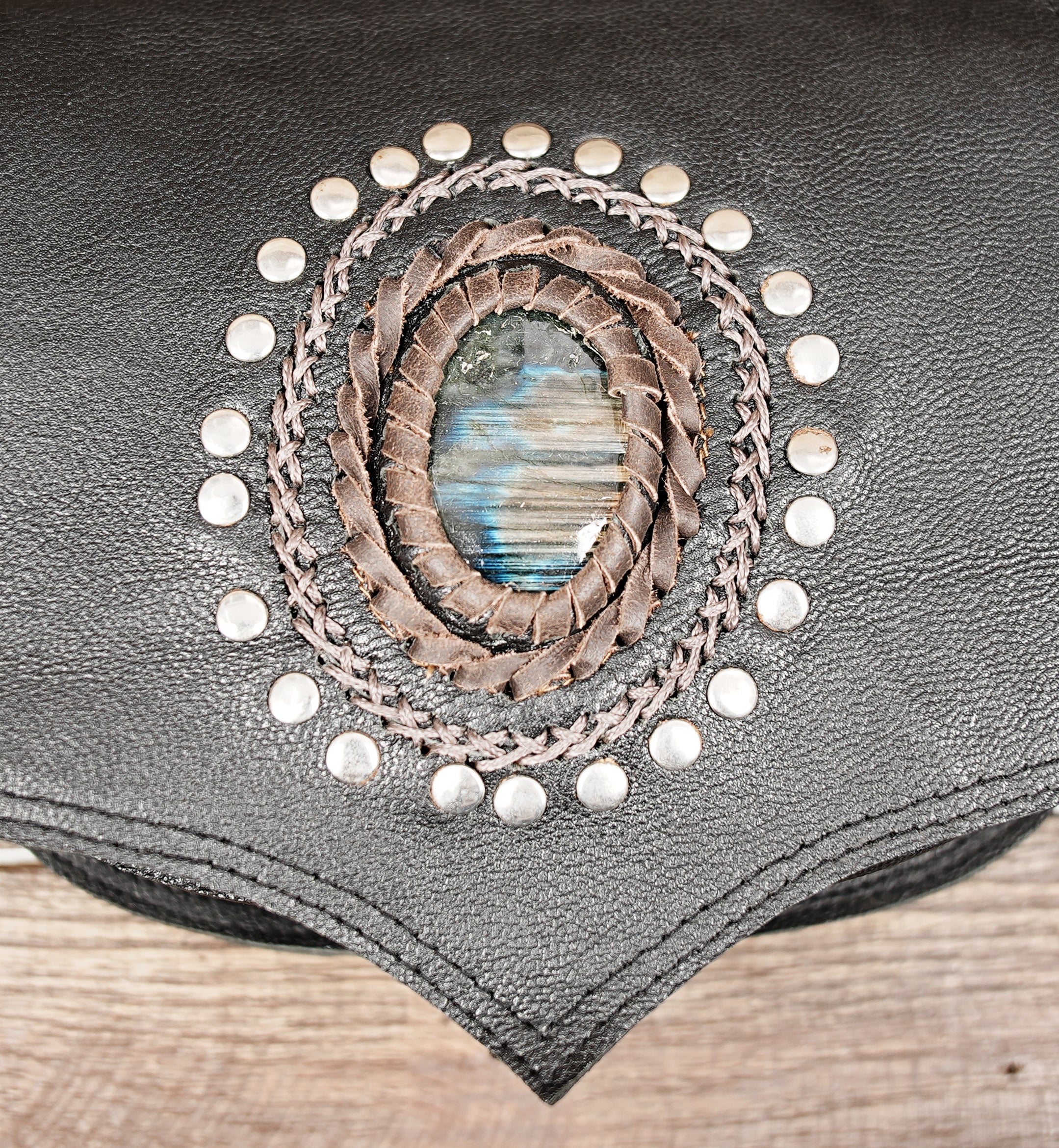 Festival-style leather waist bag with gemstone accent and adjustable buckle strap.