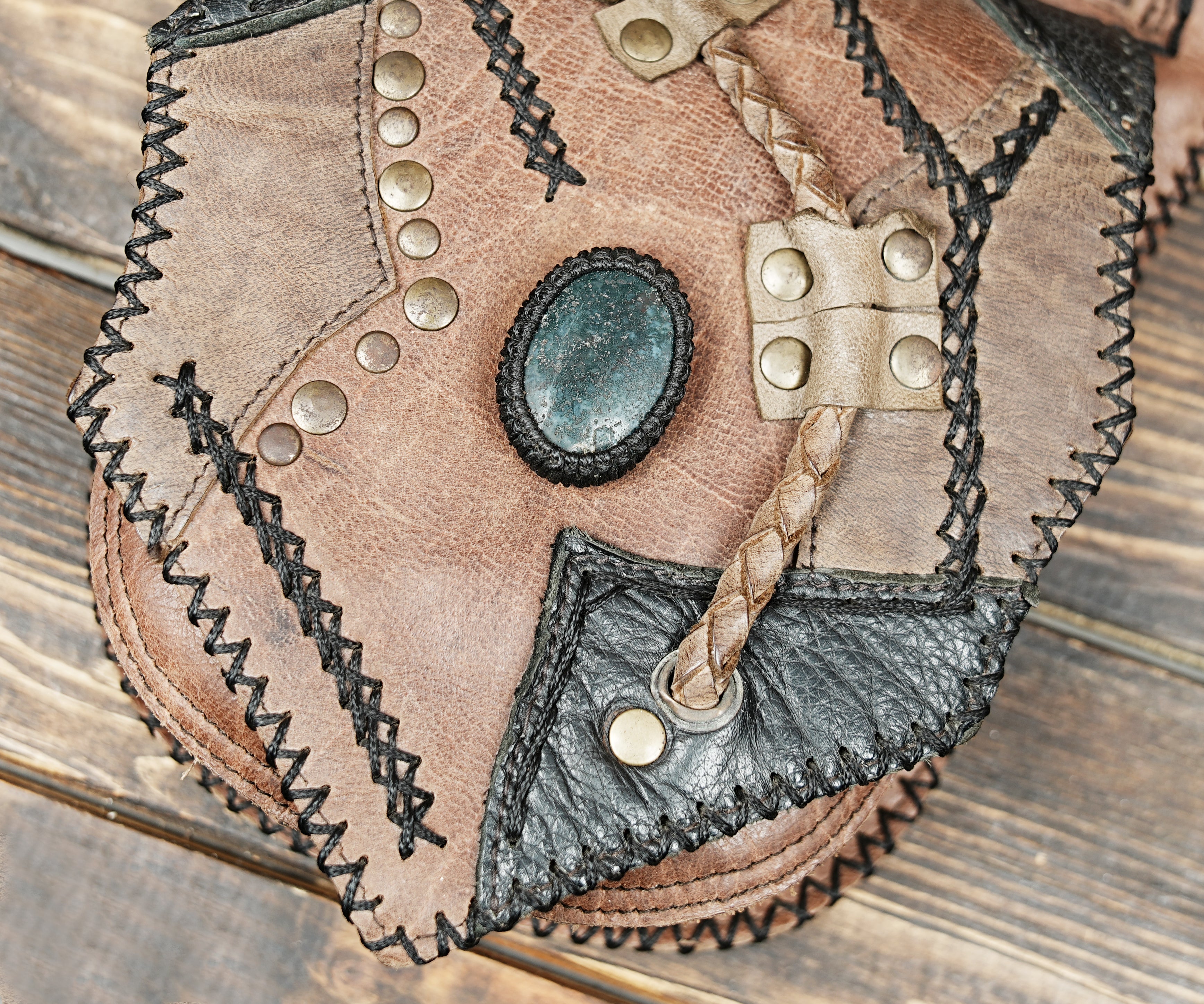 Brown and black patchwork leather hip bag with zipper pocket and metal studs