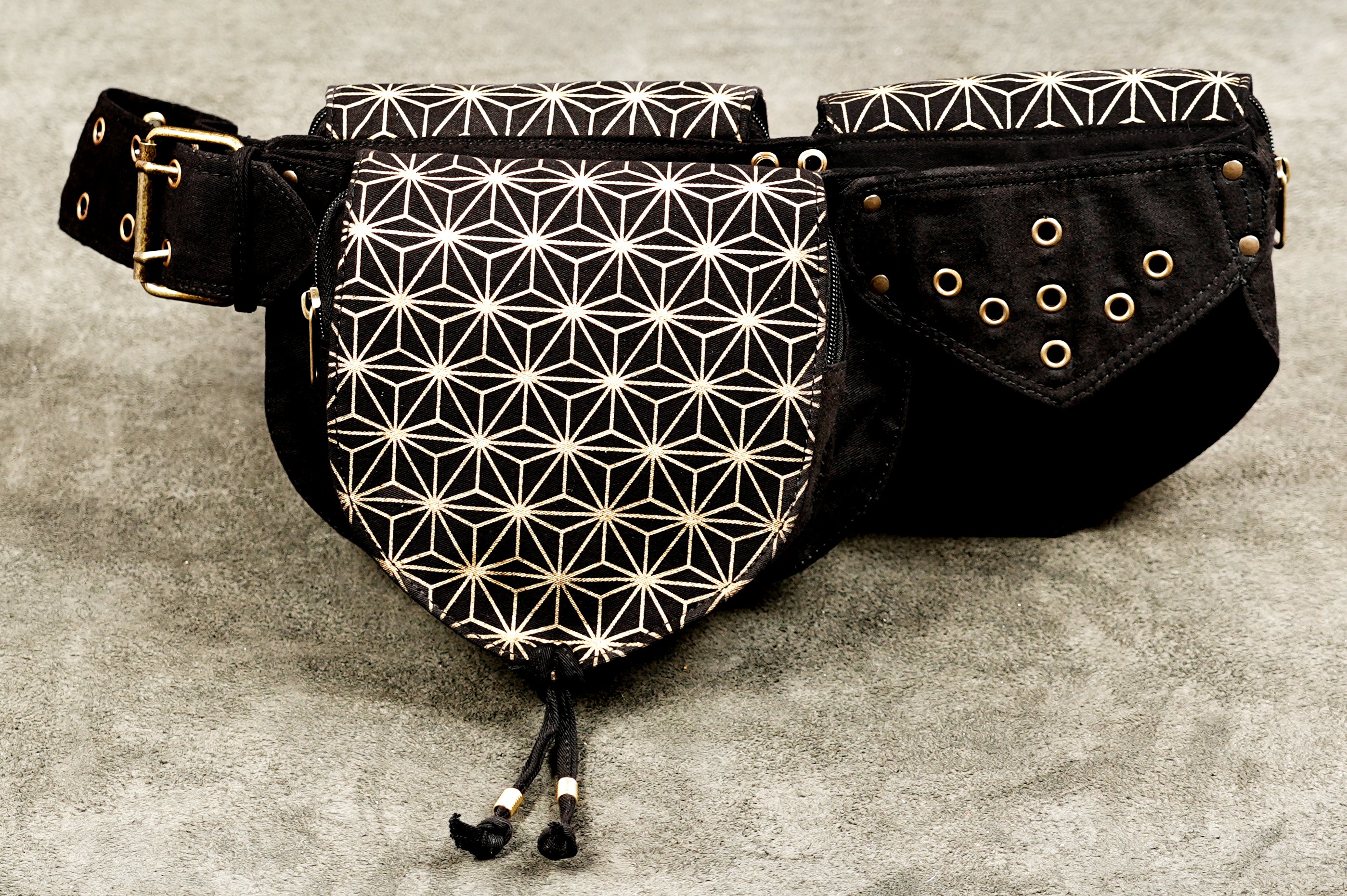 Black fanny pack with gold star pattern, multiple zip pockets, festival style